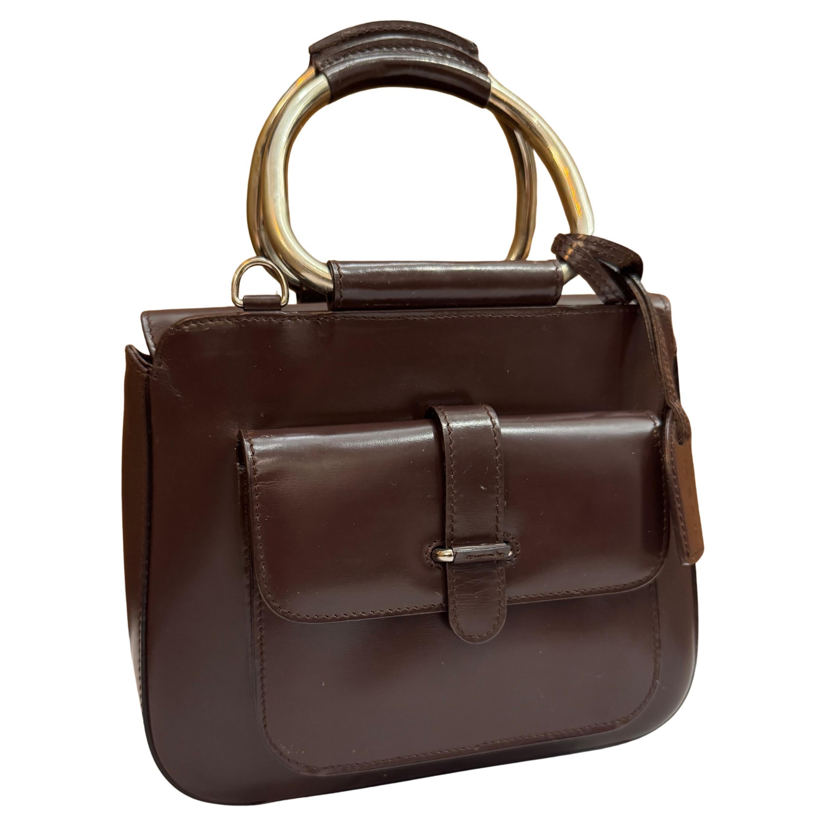 This vintage GUCCI tote bag is crafted of smooth calfskin leather in chocolate brown featuring silver toned hardware and rolled leather metallic handles. Top magnetic snap closure opens to a coated interior which has been professionally cleaned