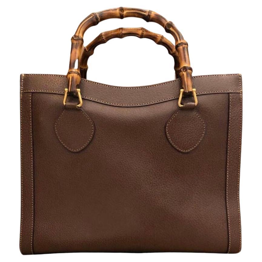 This vintage GUCCI Diana bamboo tote is crafted of pigskin’s leather in brown and matt gold toned hardware. Top magnetic snap closure opens to a new interior. It features two main compartments/one zip compartment and one interior zippered pocket.