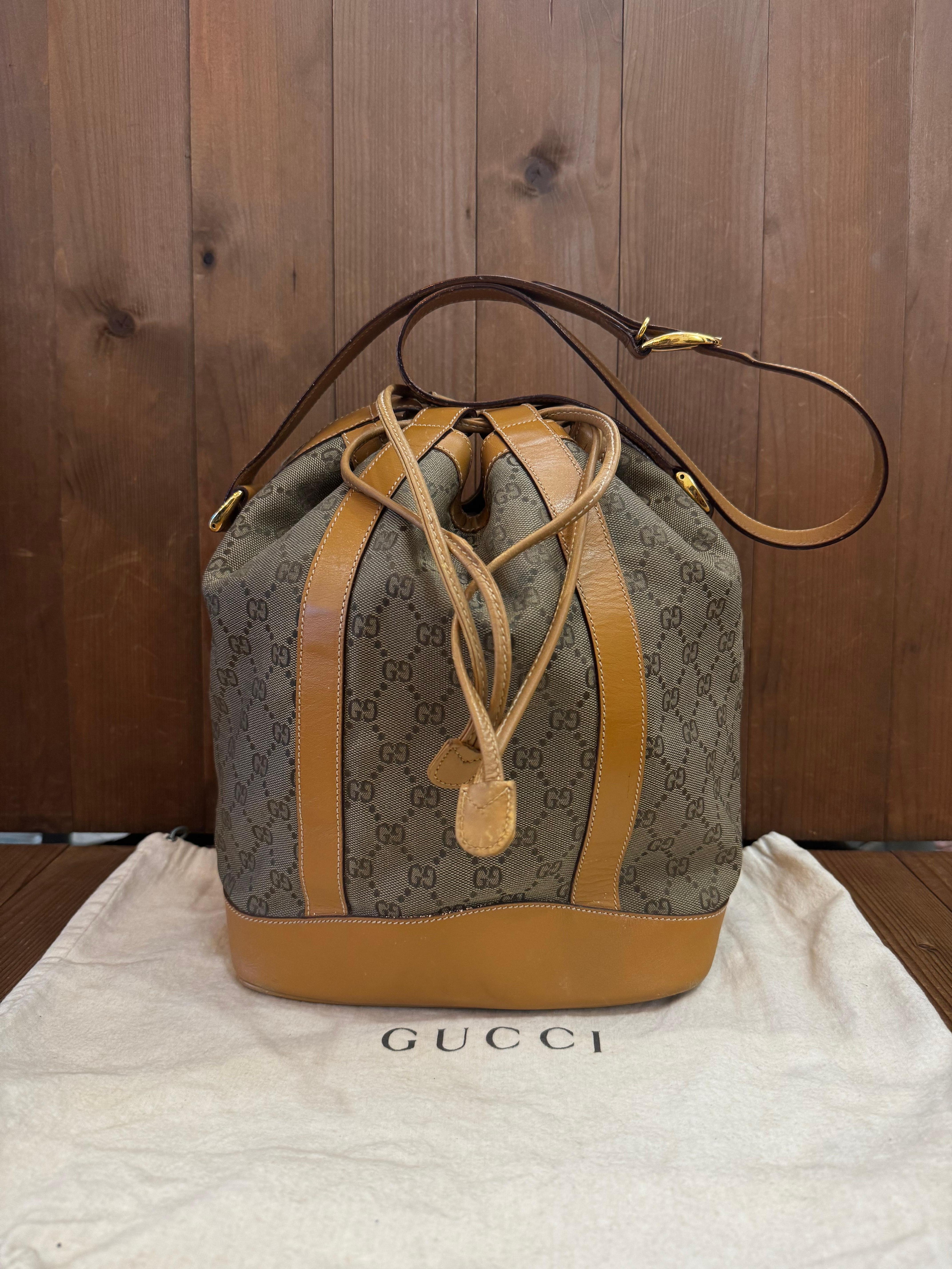 Ce sac seau GUCCI vintage est confectionné en jacquard GG en cuir kaki et tan lisse. La fermeture par cordon de serrage sur le dessus ouvre sur un intérieur enduit qui a été nettoyé par des professionnels et qui comporte une pochette à fermeture