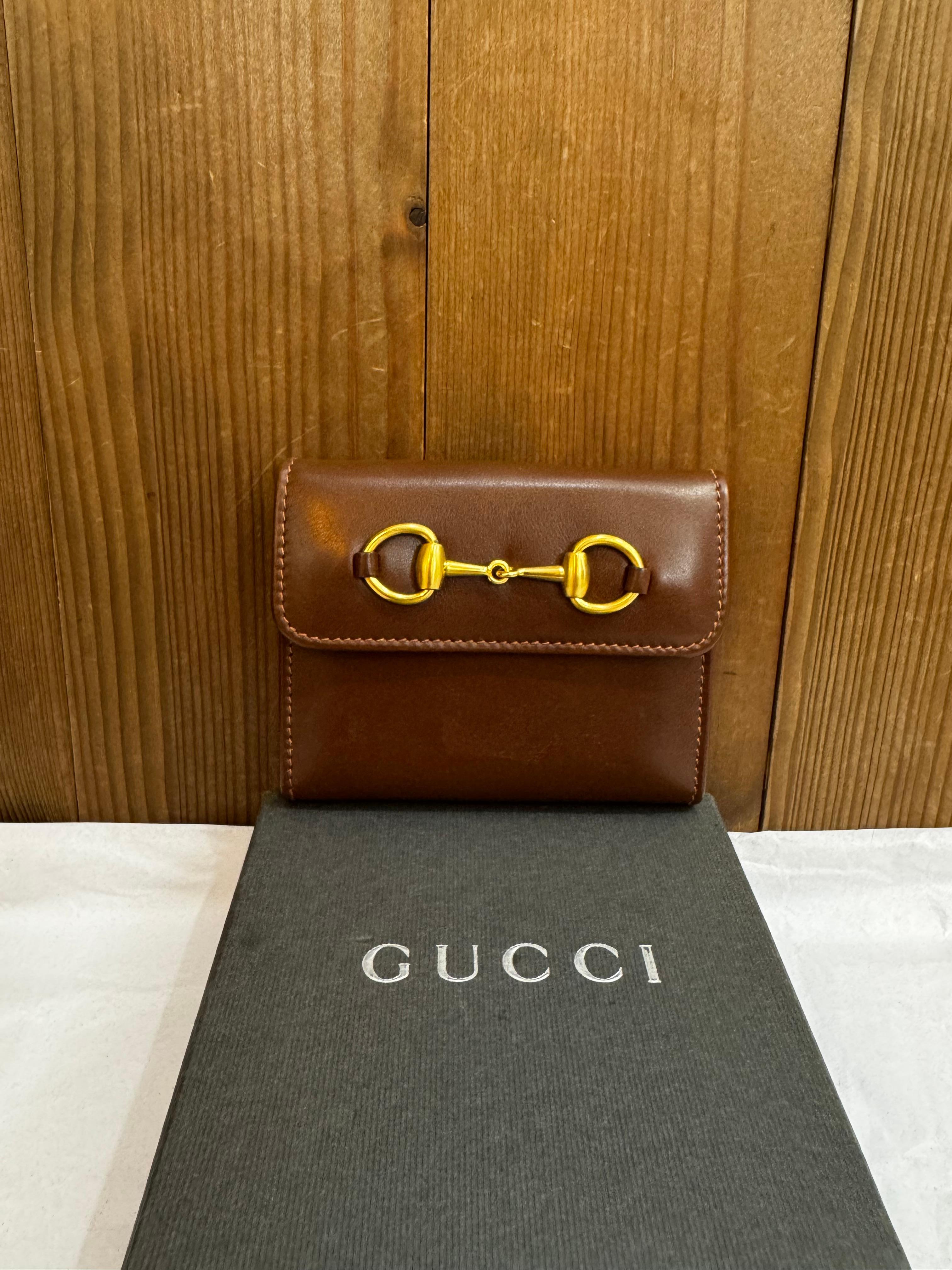 Dieses Vintage-Telefonbuch/Notizbuch von GUCCI ist aus braunem Kalbsleder gefertigt und mit einem goldfarbenen Pferdegebiss auf der Vorderseite versehen. Ein Schnappverschluss auf der Vorderseite gibt den Blick frei auf ein braunes Lederinterieur
