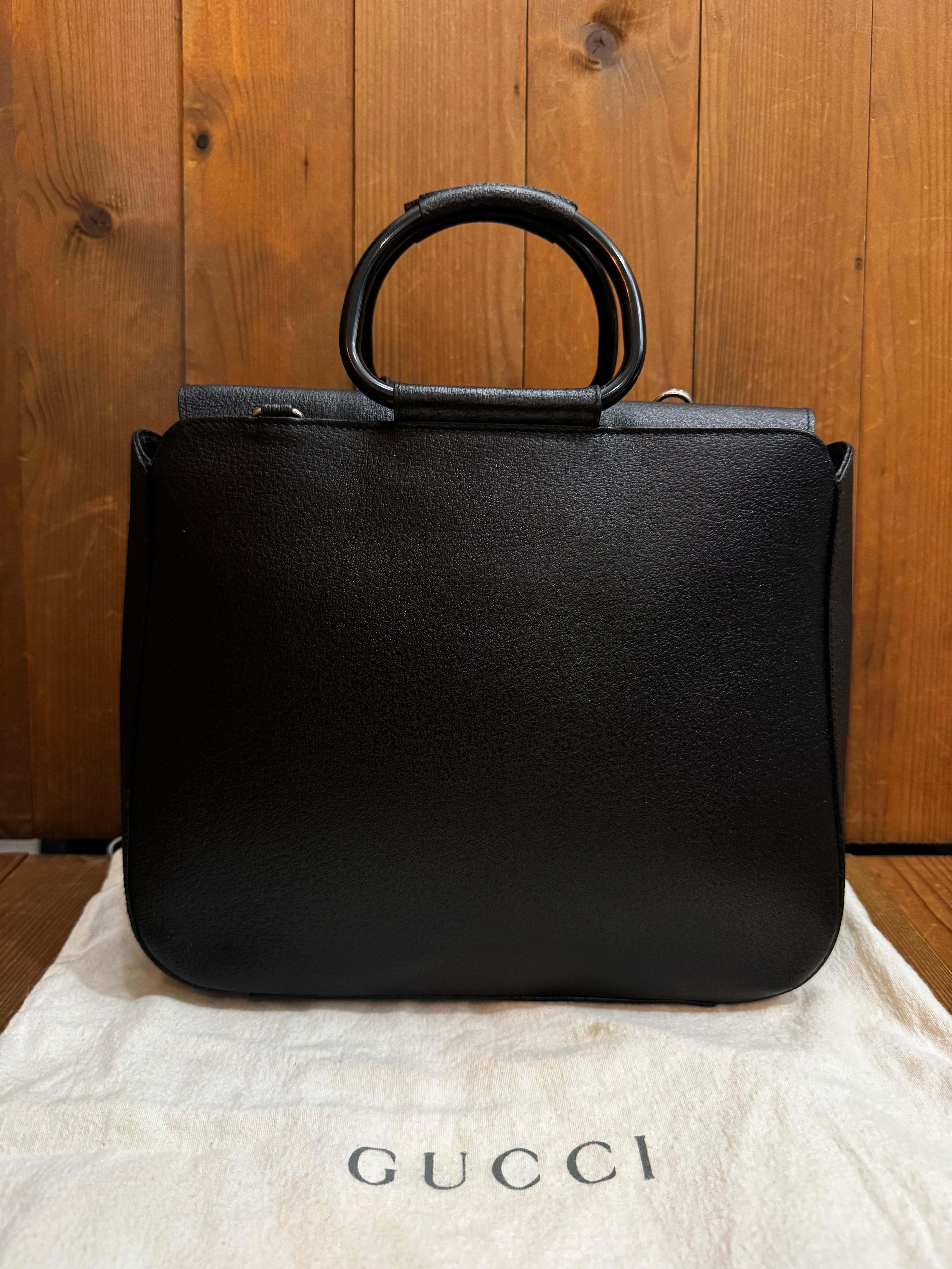 This vintage GUCCI tote bag is crafted of pigskin leather in black featuring black enameled hardware and rolled leather metallic handles. Top magnetic snap closure opens to a coated interior which has been professionally cleaned featuring a zippered