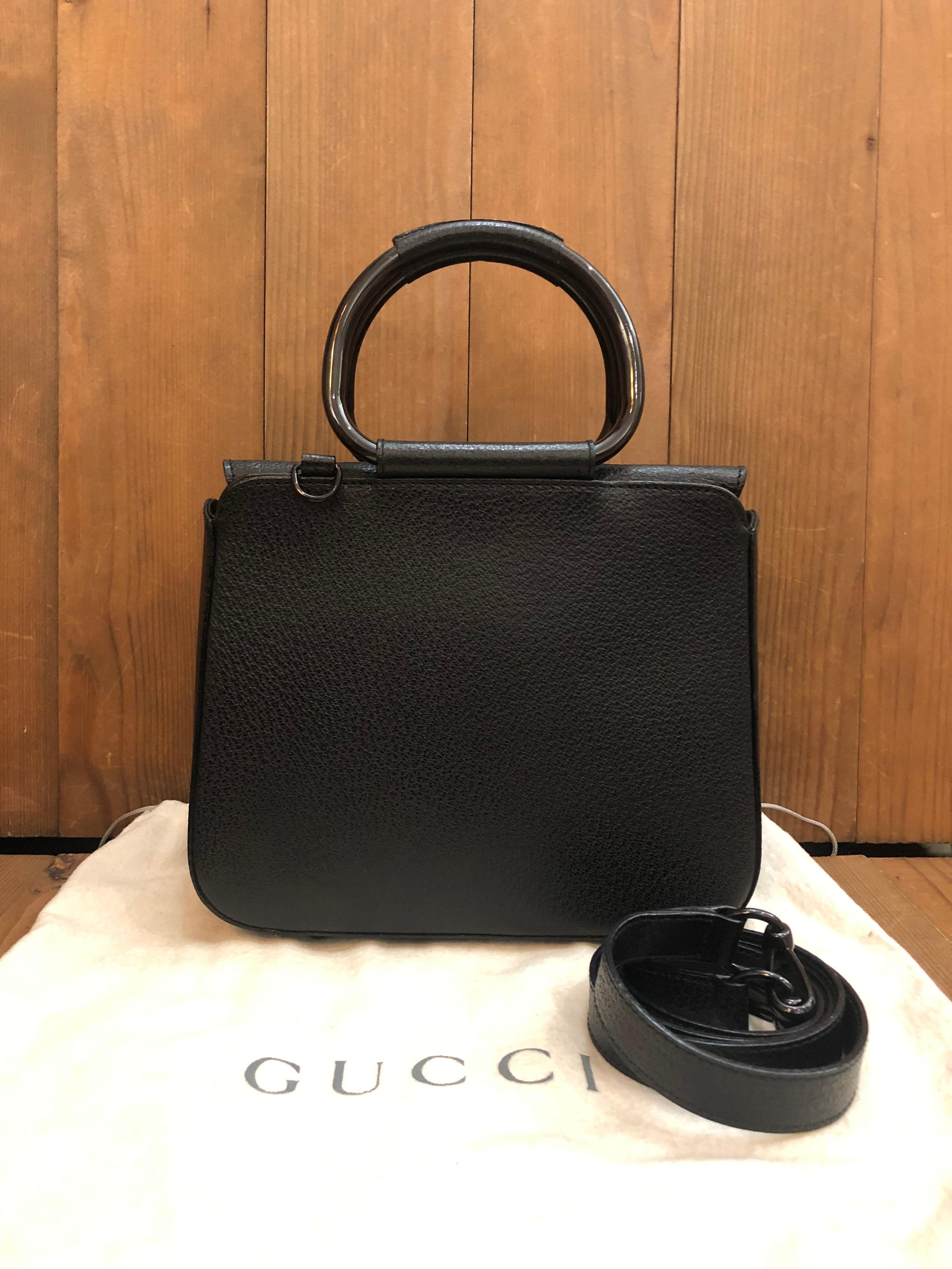 This vintage GUCCI crossbody bag is crafted of pigskin leather in black featuring black enameled hardware and rolled leather metallic handles. Top magnetic snap closure opens to a coated interior which has been professionally cleaned featuring a