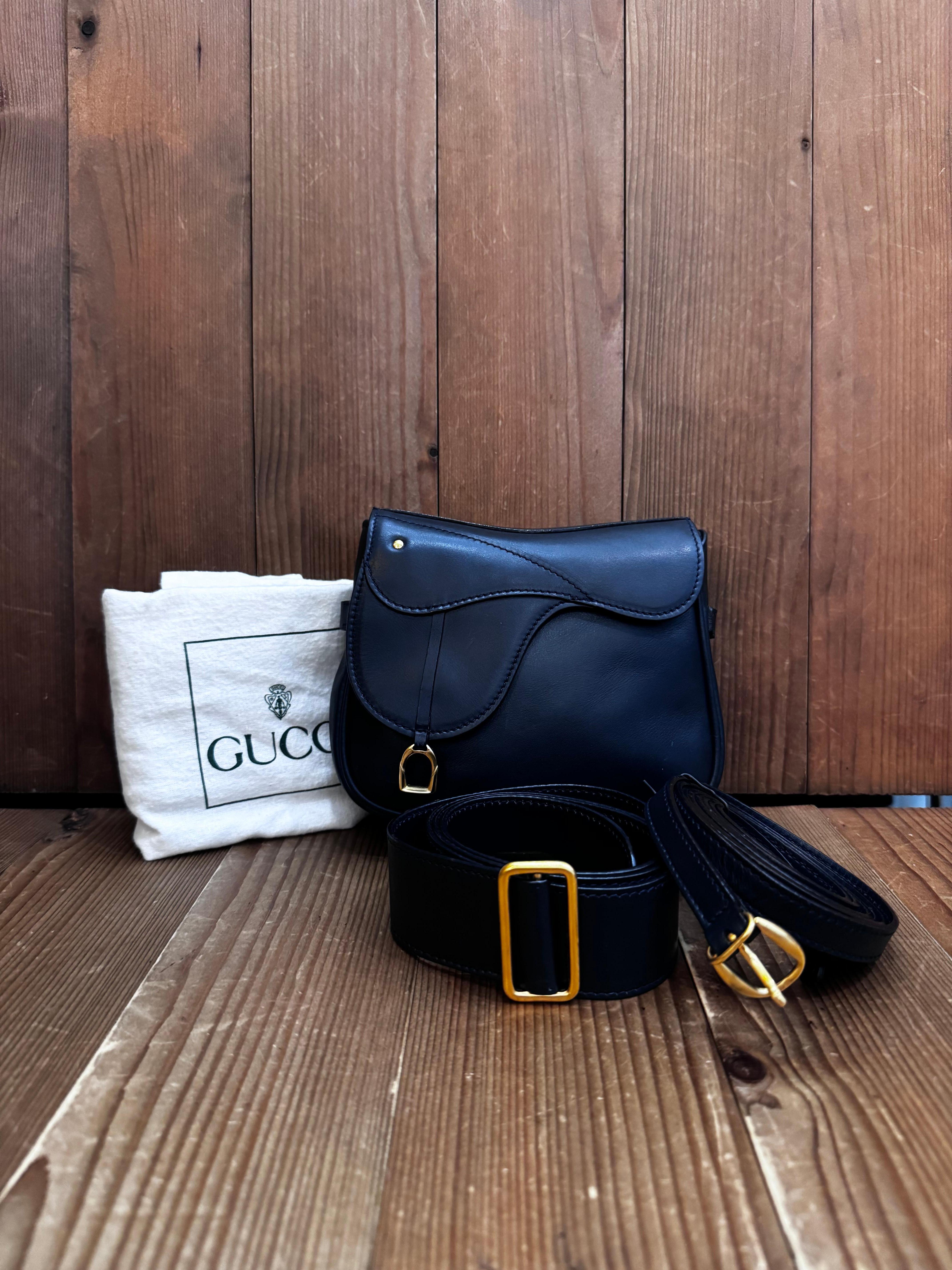 Diese Mini-Satteltasche im Vintage-Stil von GUCCI ist aus glattem Kalbsleder in Marineblau gefertigt und mit goldfarbener Hardware ausgestattet. Die Tasche verfügt über einen abnehmbaren Schulterriemen und einen Gürtel aus demselben Leder, der als