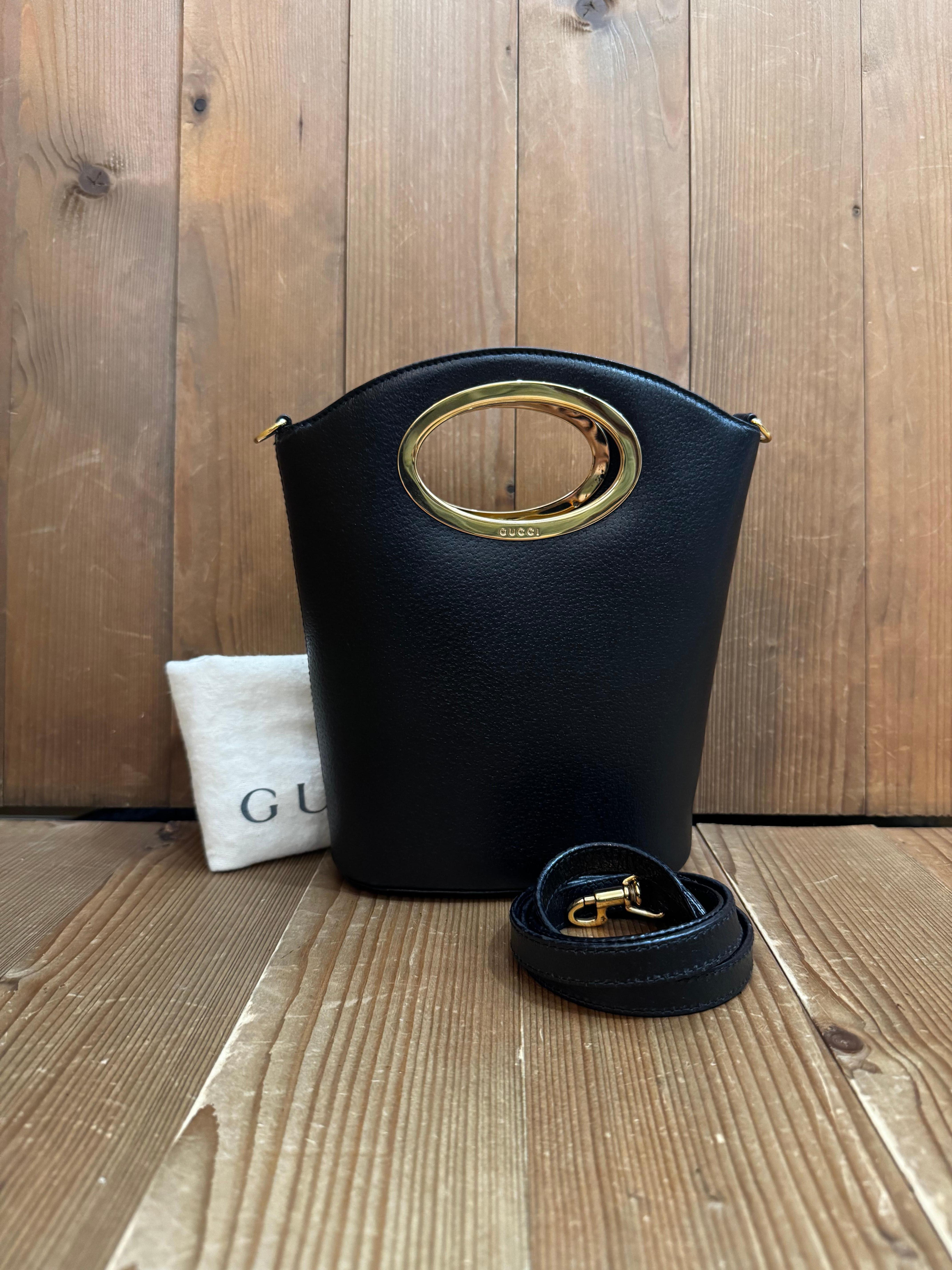 This vintage GUCCI mini two-way bucket crossbody bag is crafted of pigskin leather in black featuring gold toned hardware. Wide top handles open to a coated interior which has been professionally cleaned featuring open and zippered compartments.