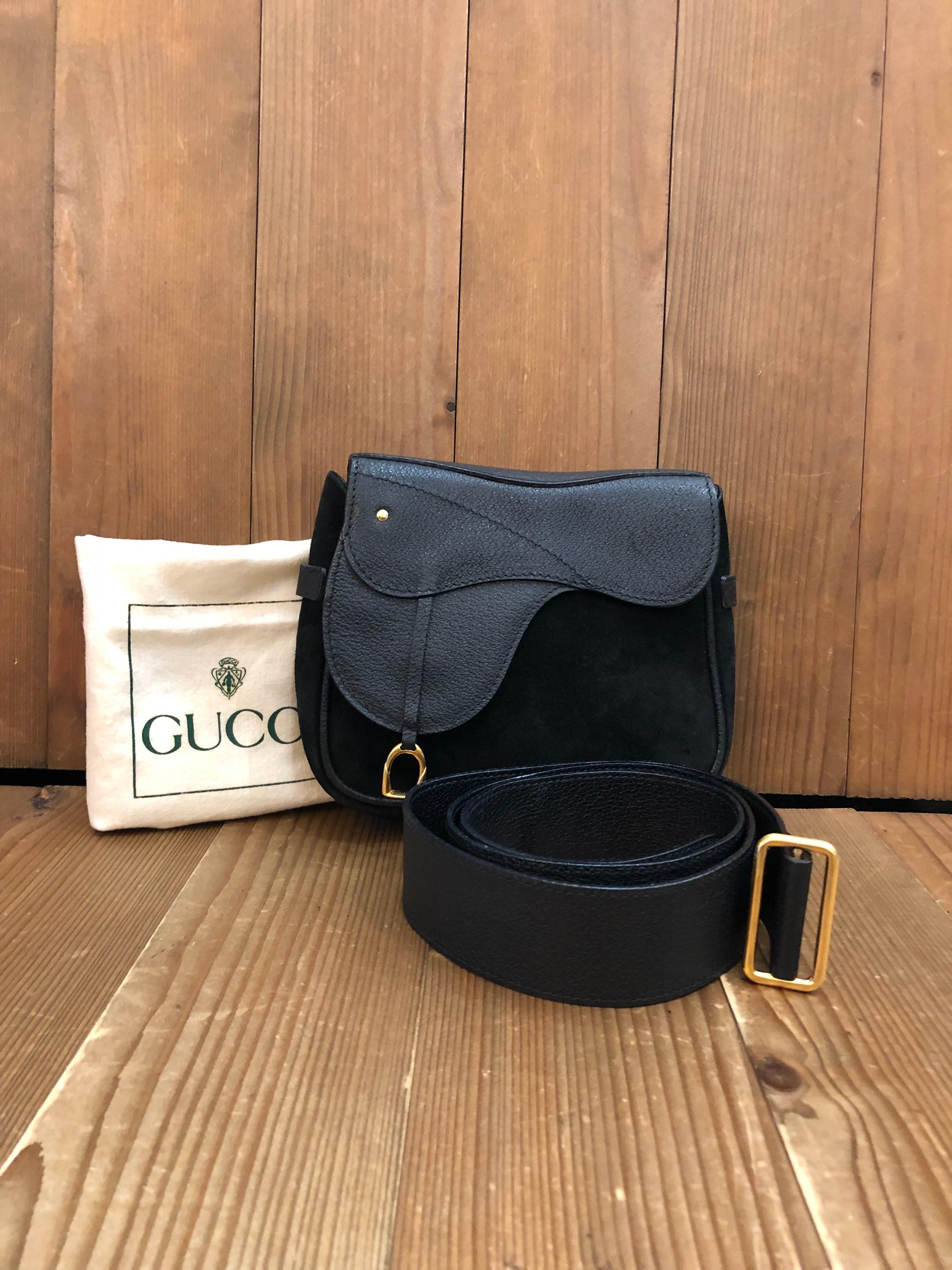 This vintage GUCCI mini saddle belt bag is crafted of pigskin and nubuck leather in black featuring gold toned hardware. Front magnetic snap closure opens to a black diamanté jacquard interior. Made in Italy. Measures approximately 6.5 x 6 x 1.5