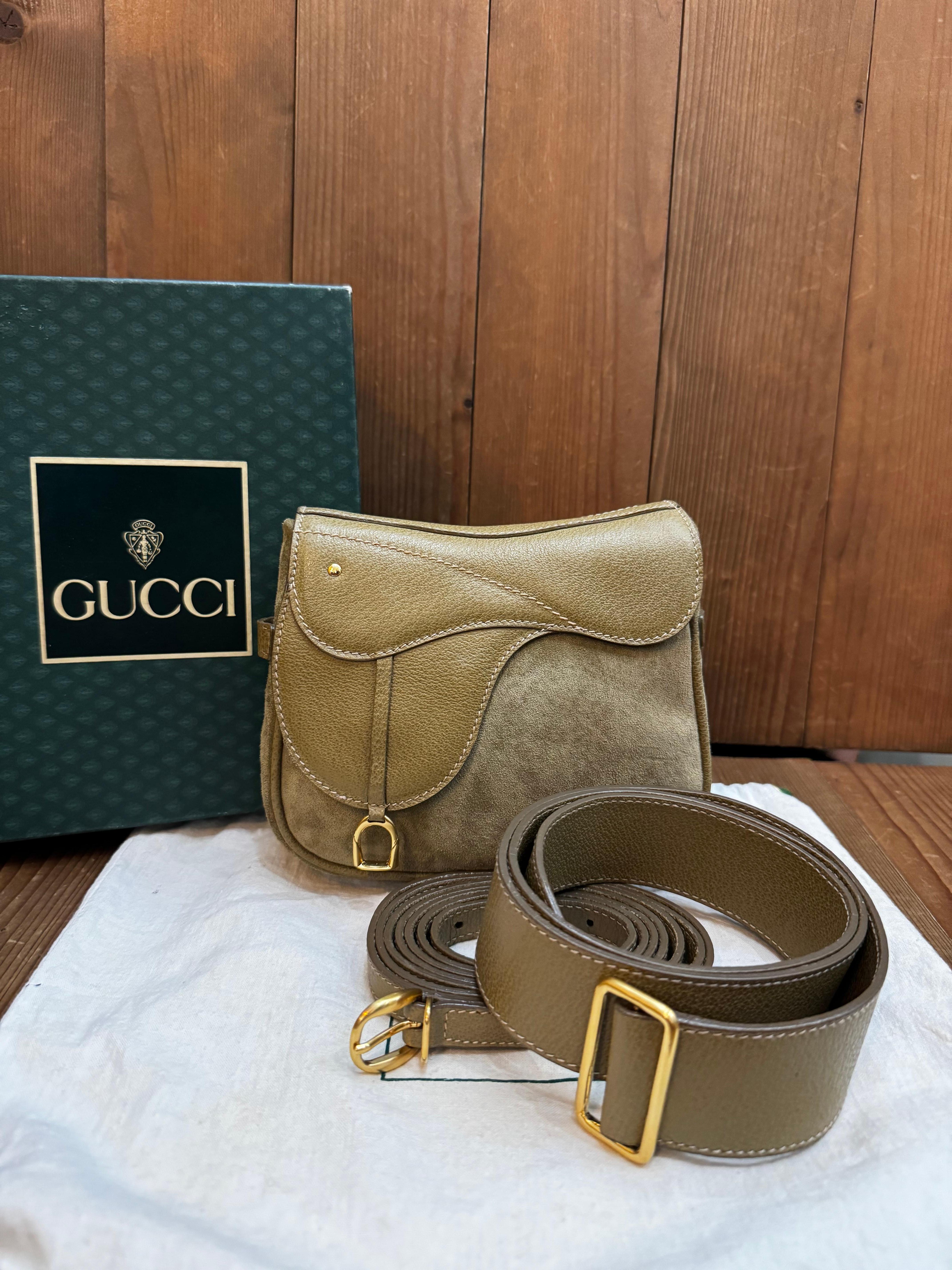 Diese Vintage-Mini-Satteltasche von GUCCI ist aus khakifarbenem Schweins- und Nubukleder gefertigt und mit goldfarbenen Beschlägen versehen. Die Tasche verfügt über einen abnehmbaren Crossbody-Riemen und einen Gürtel aus demselben Leder, mit dem sie