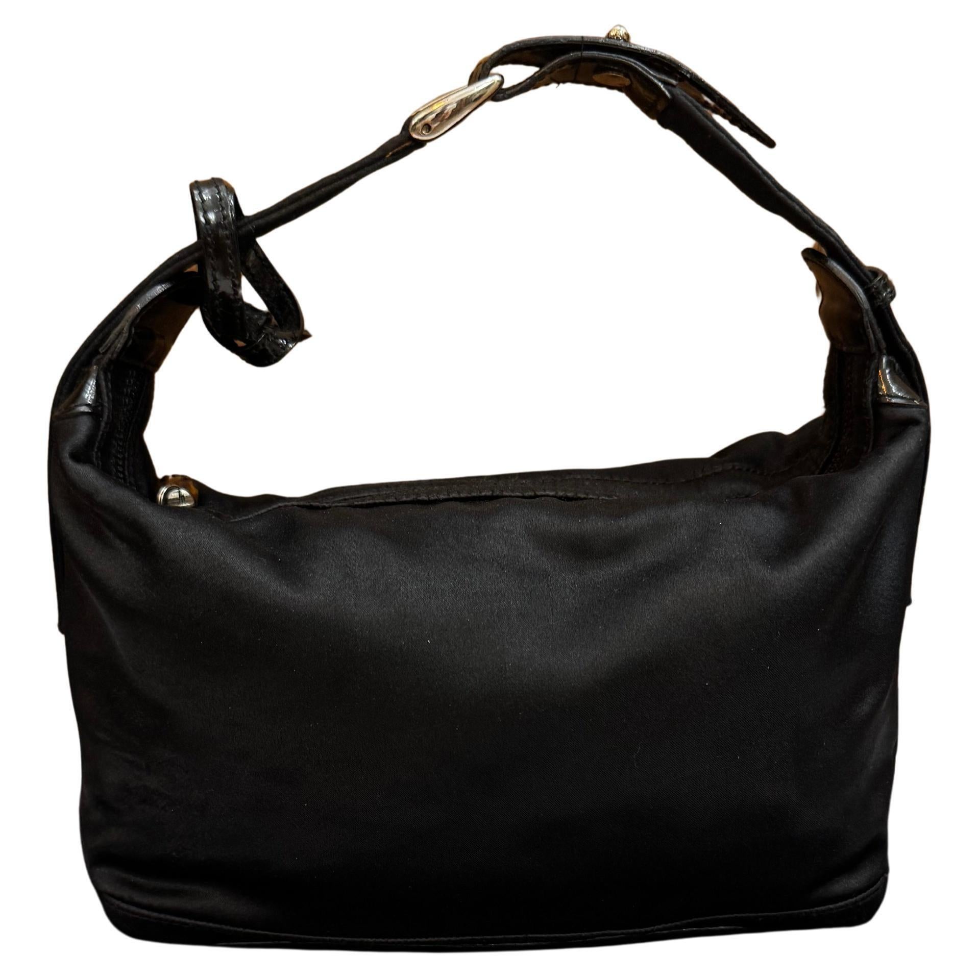 Ce mini sac à main vintage de Gucci est réalisé en satin noir avec des garnitures en cuir verni noir. La fermeture à glissière en bambou sur le dessus ouvre sur un intérieur Coates qui a été nettoyé par des professionnels. Fait en Italie. Mesure