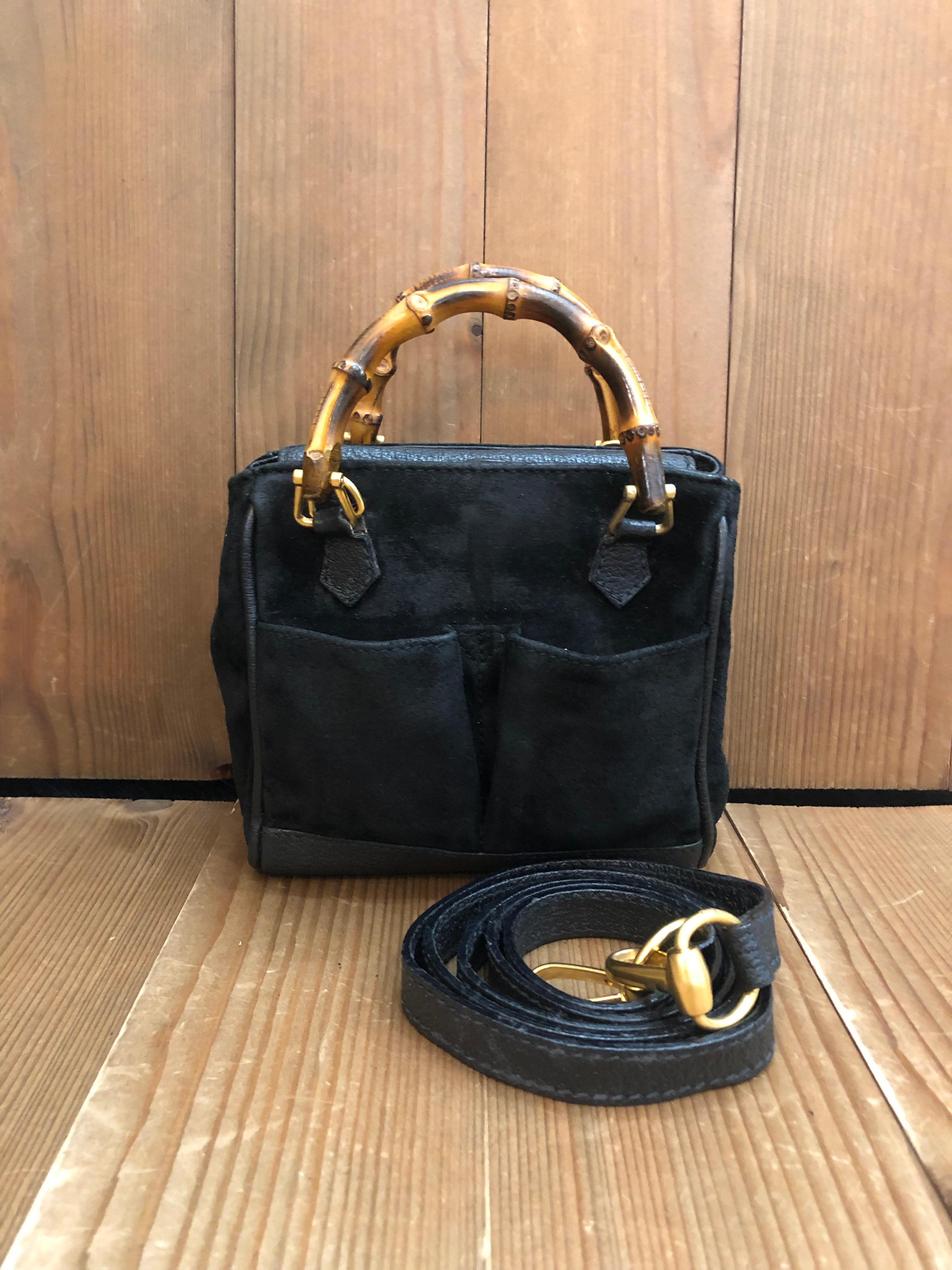 This 1990s vintage GUCCI mini 2-way bamboo crossbody bag is crafted of pigskins and nubuck leather in black featuring matt gold toned hardware and bamboo handles. The front of this bag features two open pockets lined with diamanté jacquard. Top