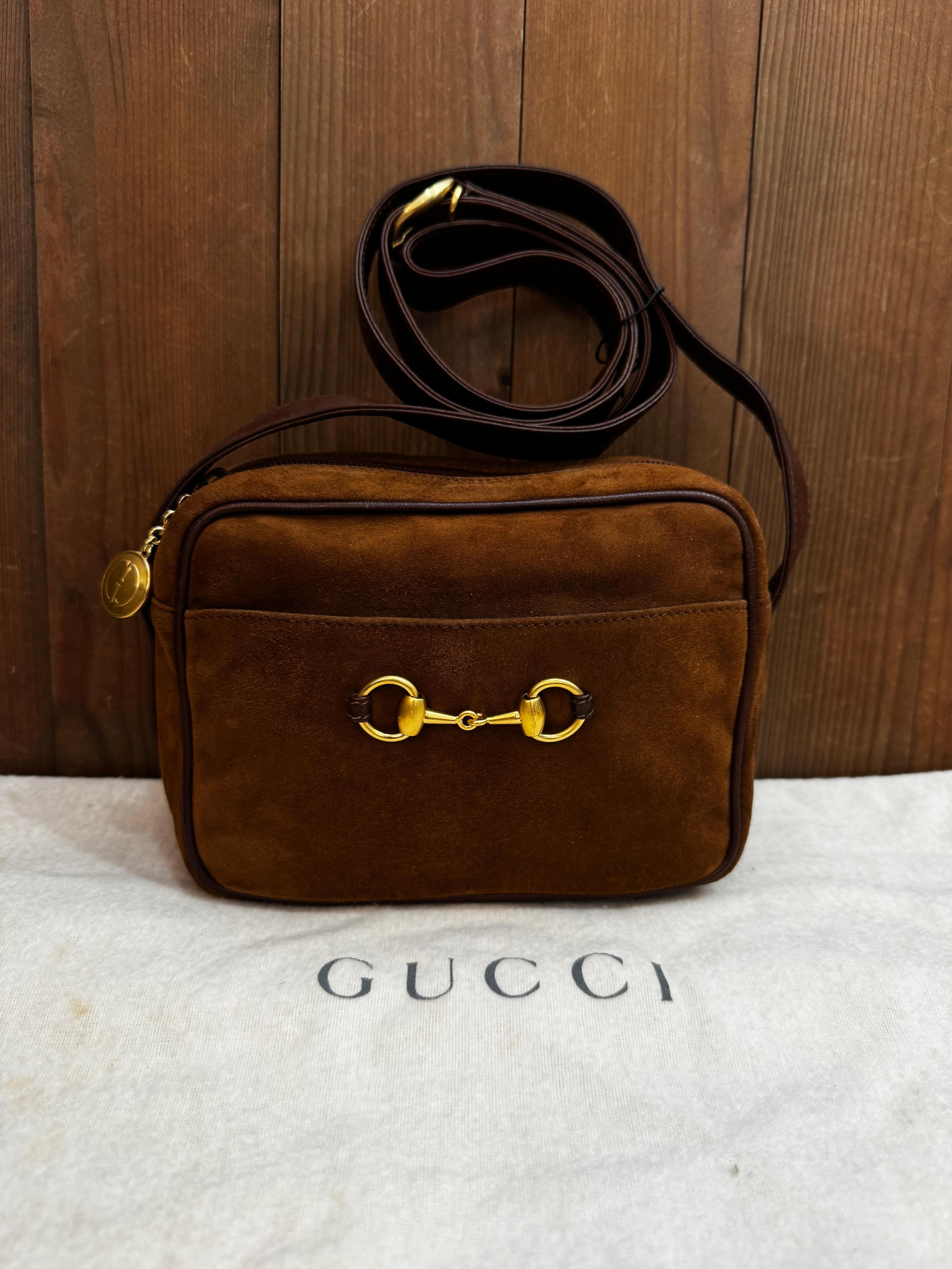 This vintage GUCCI small camera crossbody bag is crafted of smooth calfskin and nubuck leather in brown. Top zipper closure opens to a coated interior which has been professionally cleaned featuring a zippered pocket. The exterior of this Gucci also