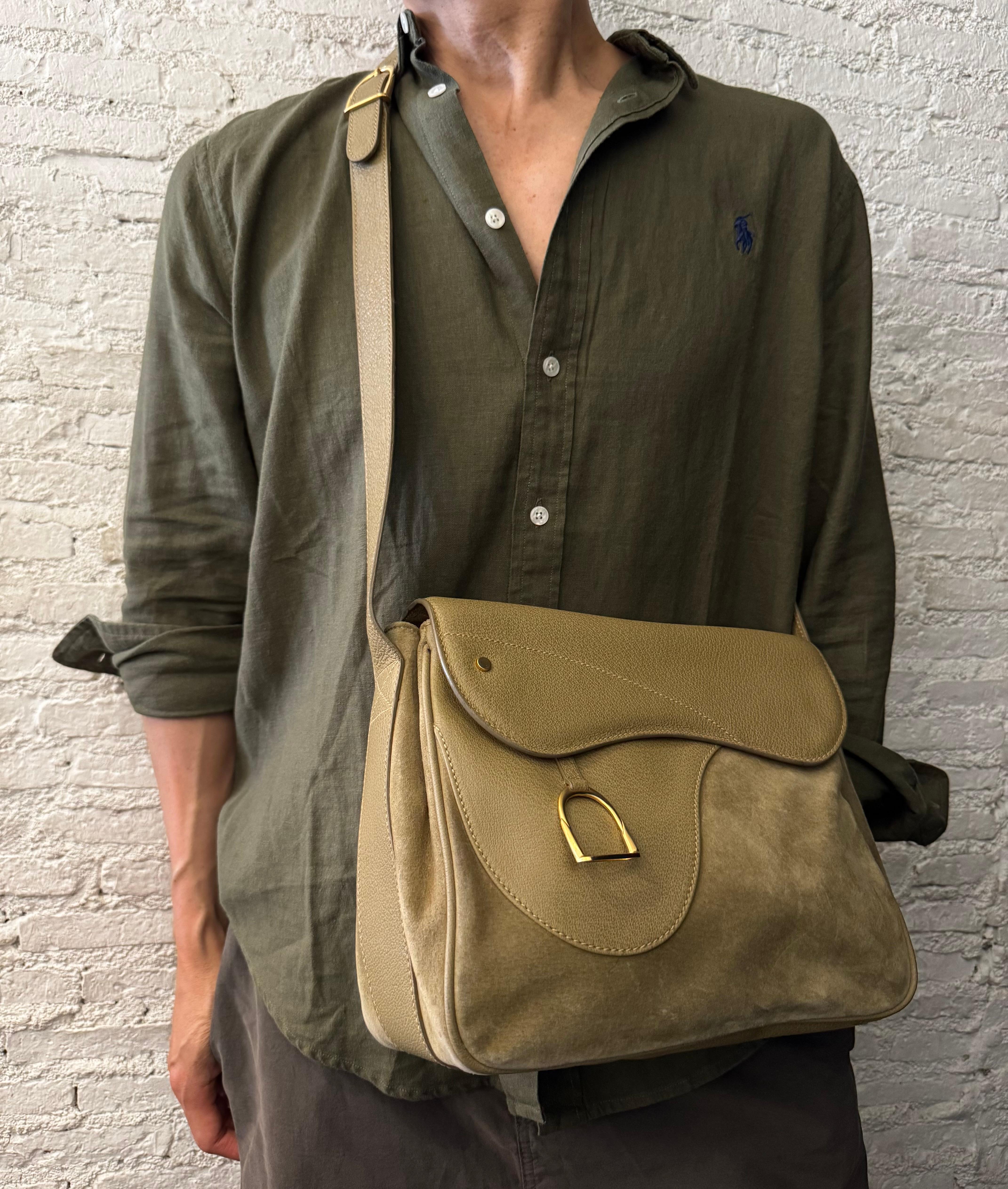 Diese Vintage-Sattelkameratasche von GUCCI ist aus khakifarbenem Nubuk- und Schweinsleder gefertigt und mit mattgoldenen Beschlägen versehen. Die Frontklappe mit doppeltem Magnetverschluss und Steigbügel-Charme gibt den Blick frei auf ein