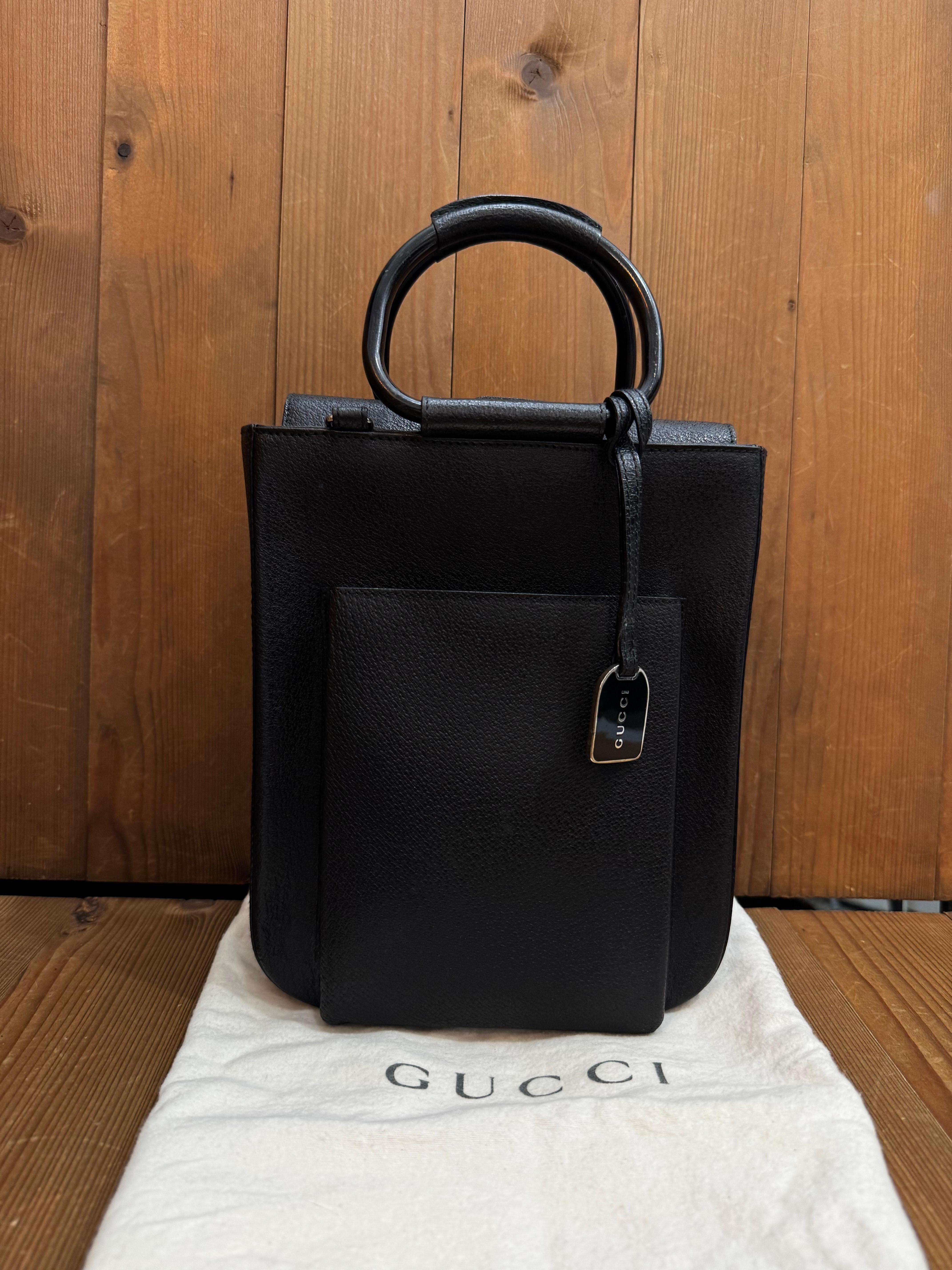 This vintage GUCCI tote bag is crafted of pigskin leather in black featuring black enameled hardware and rolled leather metallic handles. Top magnetic snap closure opens to a coated interior which has been professionally cleaned featuring a zippered