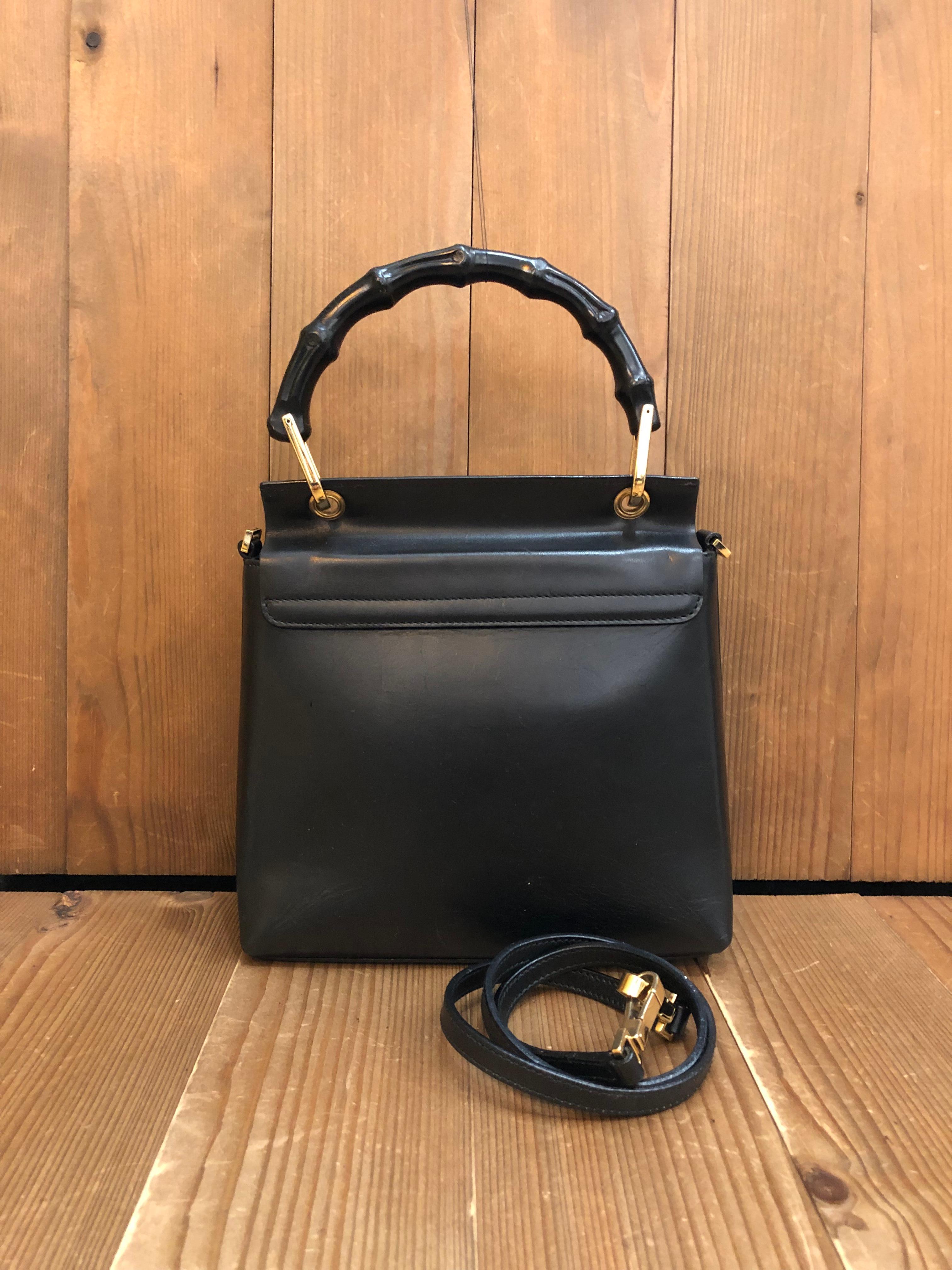 This vintage GUCCI bamboo top handle bag is crafted of smooth calfskin leather in black featuring gold toned hardware and a black bamboo handle. Front flap magnetic snap closure opens to a luxurious nubuck leather interior in black featuring a