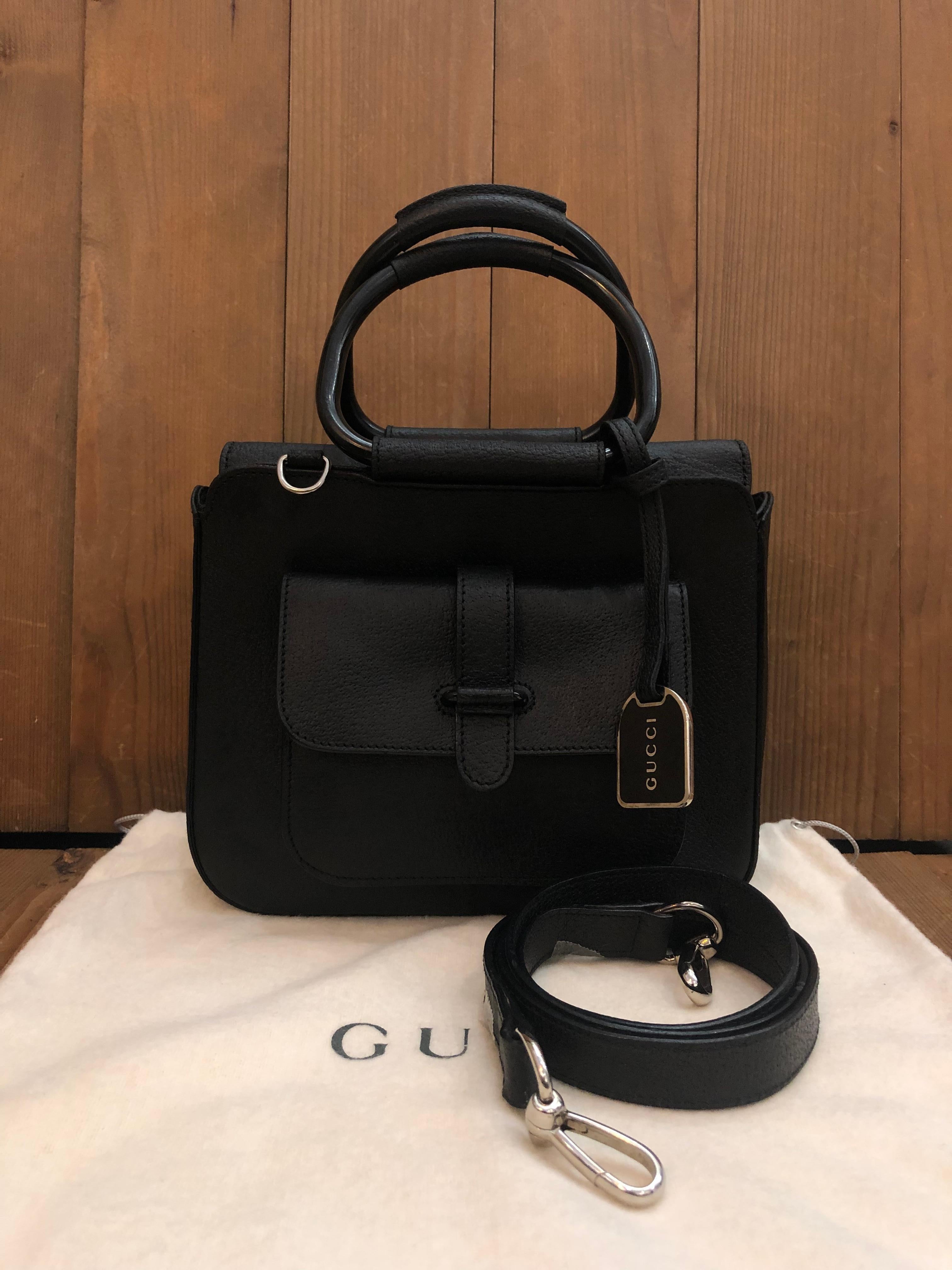 This vintage GUCCI crossbody bag is crafted of pigskin leather in black featuring silver toned hardware and rolled leather metallic handles. Top magnetic snap closure opens to a coated interior which has been professionally cleaned featuring a