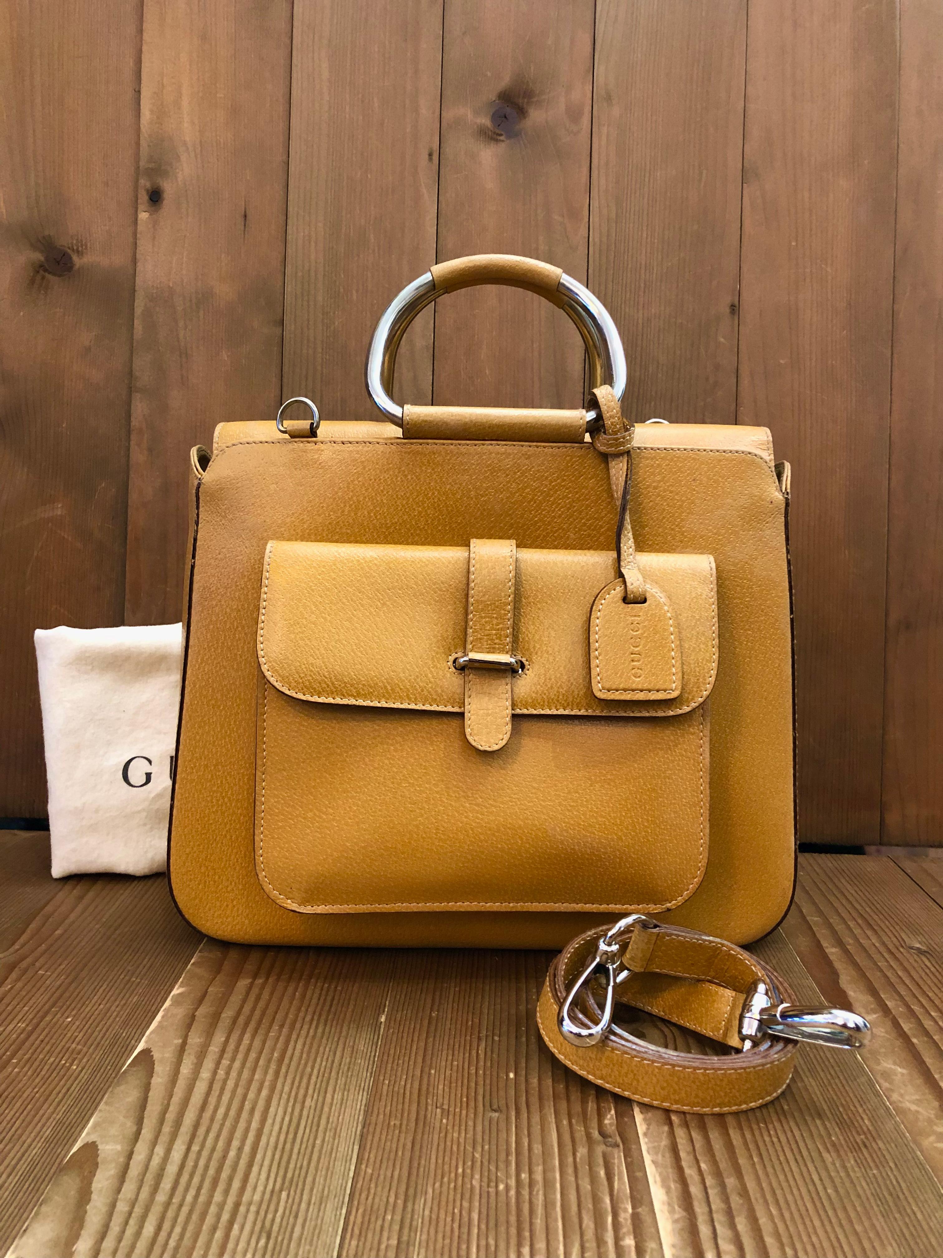 Ce sac à bandoulière vintage de Gucci est réalisé en cuir de porc jaune moutarde et présente des accessoires argentés ainsi que des anses métalliques en cuir roulé. La fermeture magnétique du haut ouvre sur un nouvel intérieur Coates en beige avec