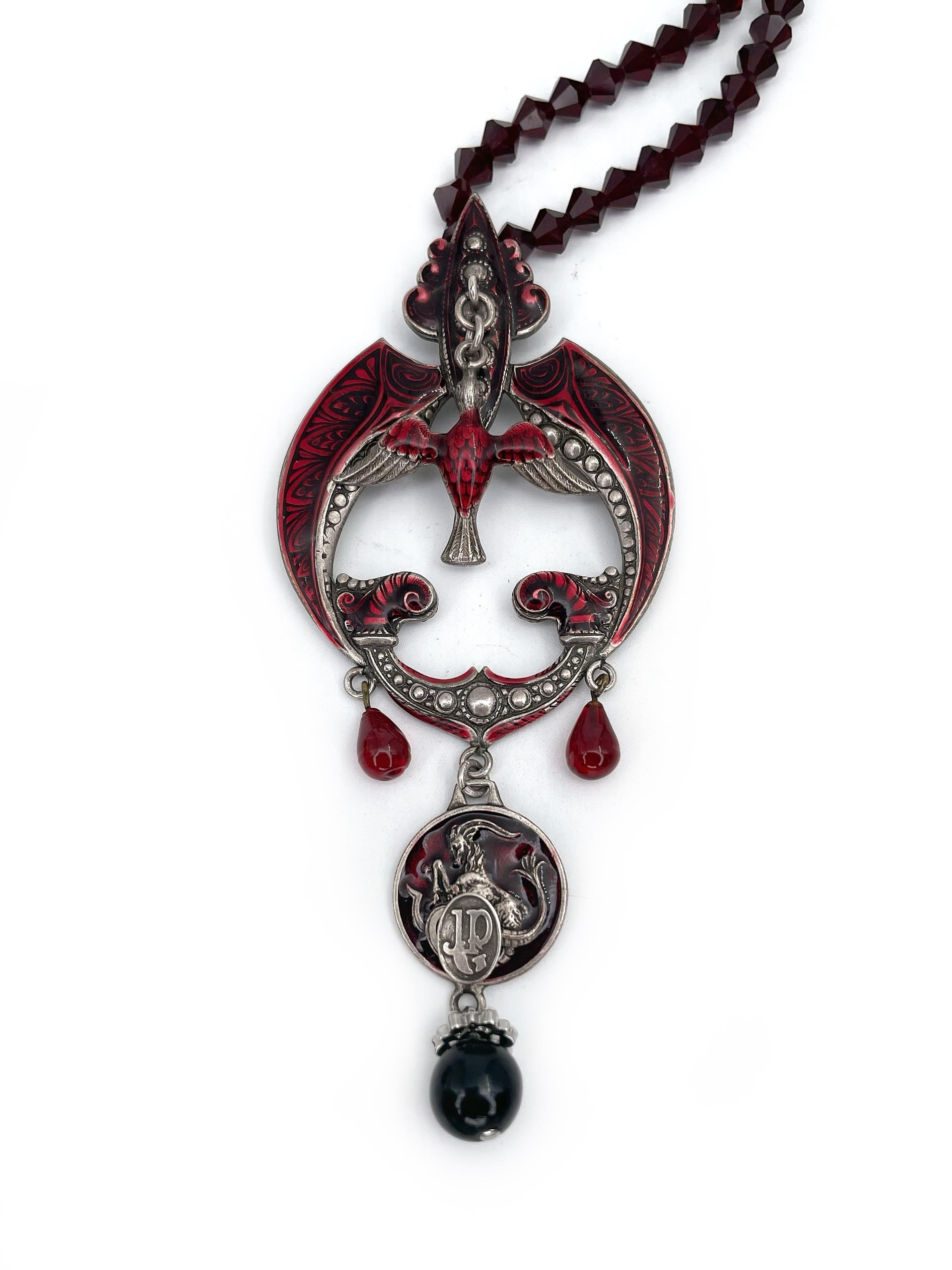 This is a highly decorated gothic necklace designed by Jean Paul Gaultier in 1990s. This piece is silver plated and adorned with dark red enamel. It features silver tone details and red glass beads.

Signed: “Gaultier” (shown in photos).

Pendant