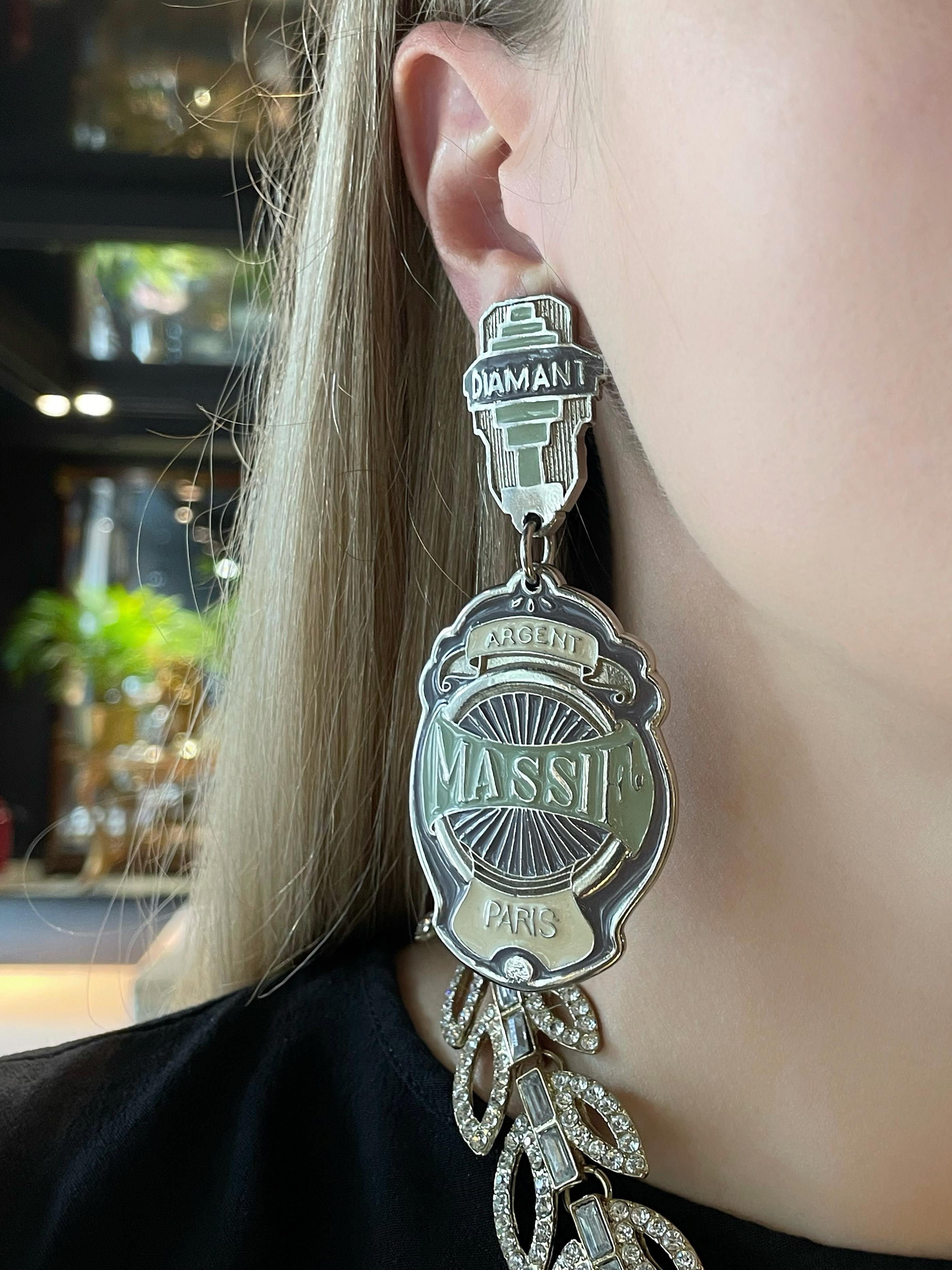 This is a vintage pair of massive dangling clip on earrings designed by Jean Paul Gaultier in 1990’s. The piece is crafted in silver tone and is adorned with enamel.

Heavy, but firmly sits on the ear.

“Diamant. Argent. Massif. Paris