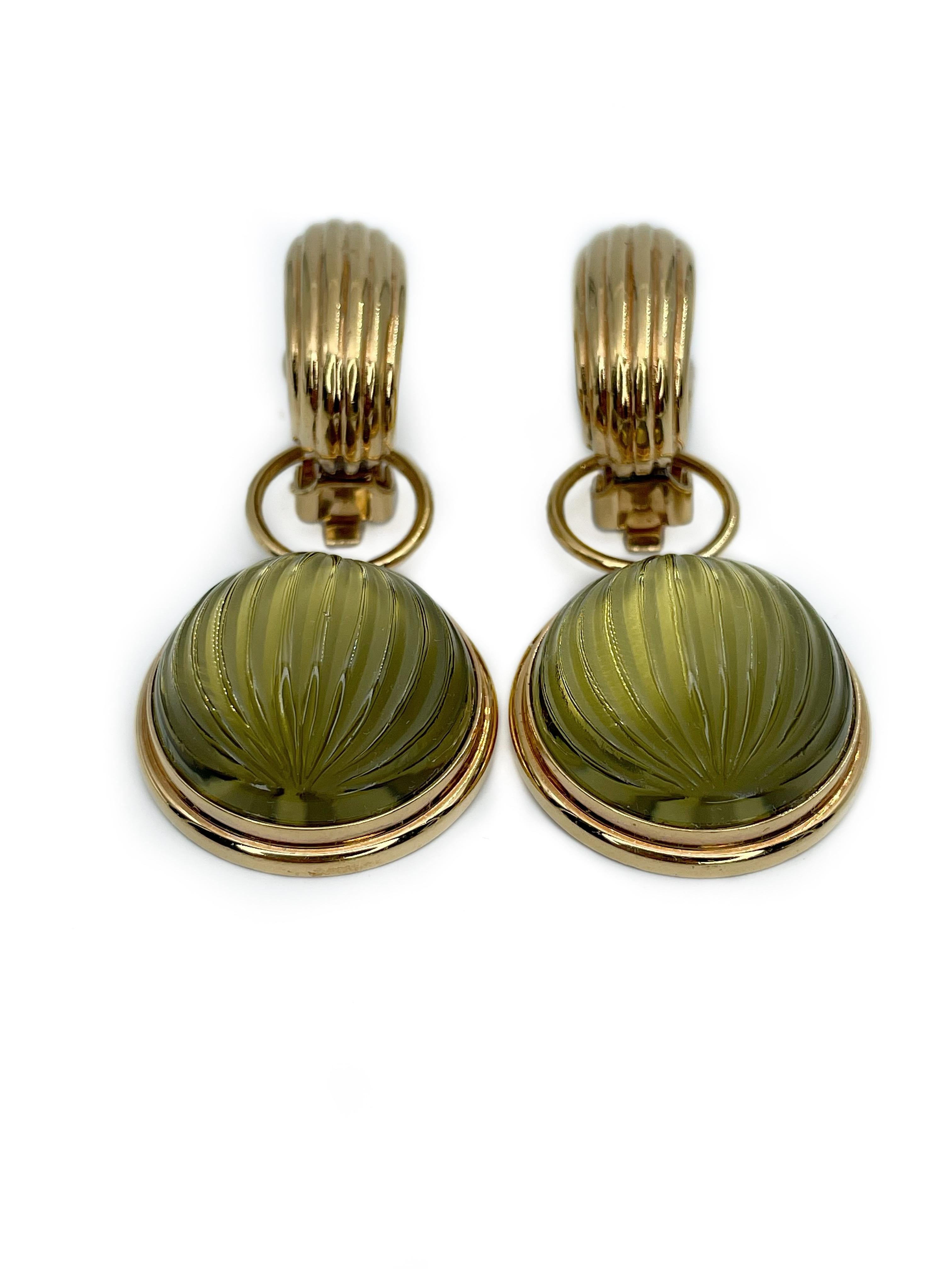 This is a gorgeous pair of large gold tone clip on earrings designed by Lalique in 1990’s. The piece is gold plated and features beautiful olive green pressed glass cabochons. These earrings can be worn in different ways by removing the bottoms.