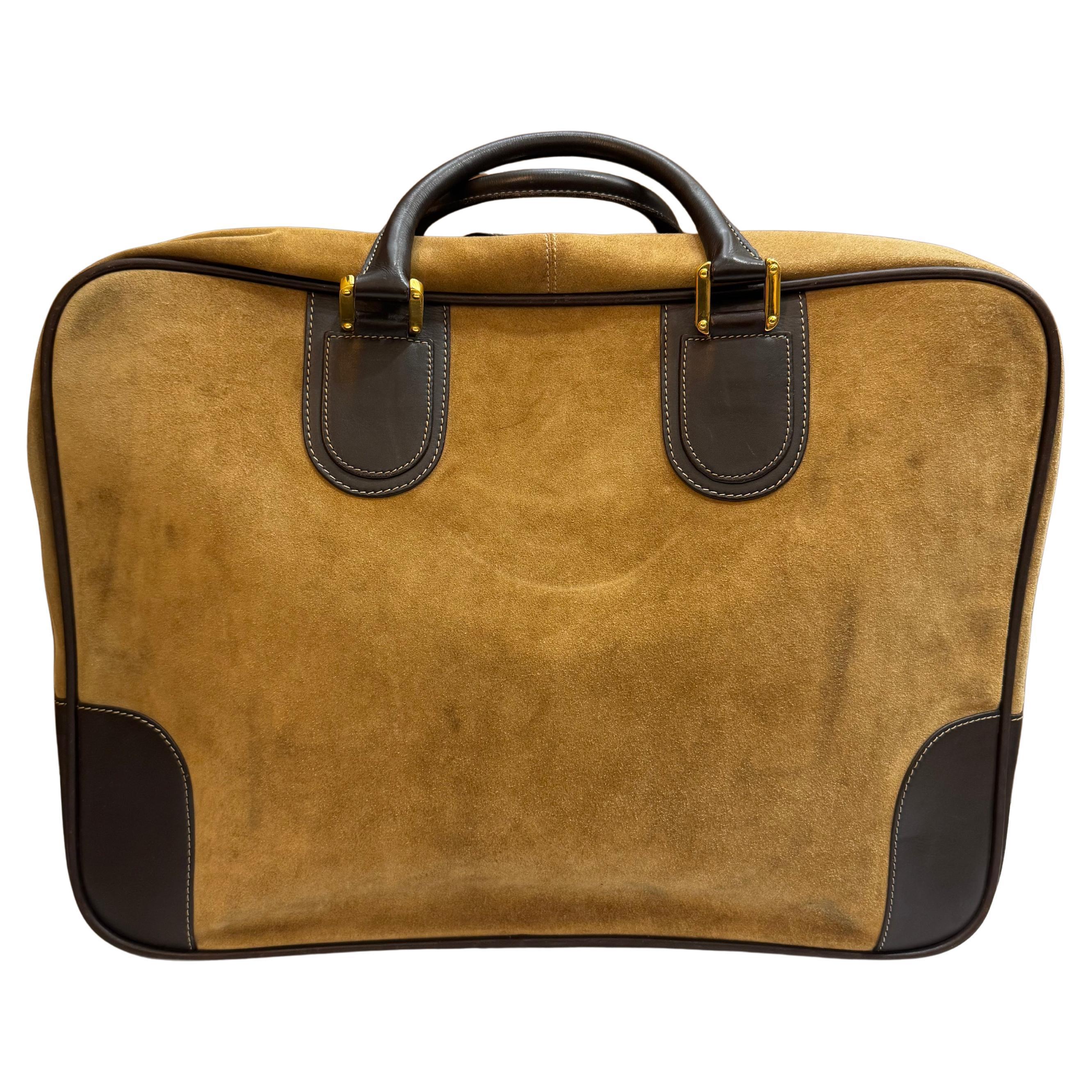 This vintage LOEWE softsided suitcase is crafted of calfskin suede and smooth calfskin leather in brown. Zip-around closure opens to a Loewe’s anagram fabric interior featuring a detachable pouch of the same fabric. Made in spain. Measures