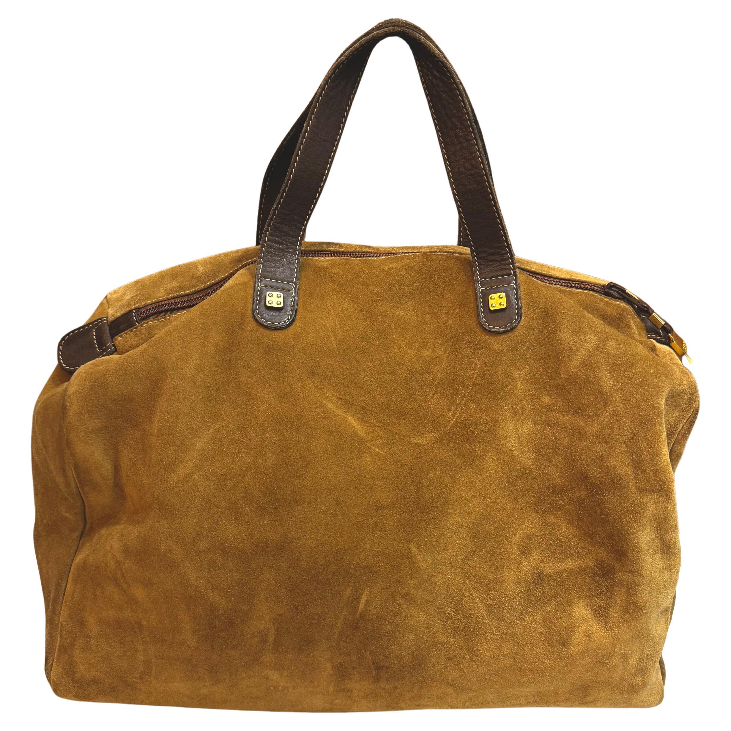 This vintage LOEWE Anagram boston bag is crafted of calfskin suede trimmed with smooth calfskin leather in brown featuring gold toned hardware. Rolled leather handles sit comfortably on shoulder. Top zipper closure opens to an unlined calfskin