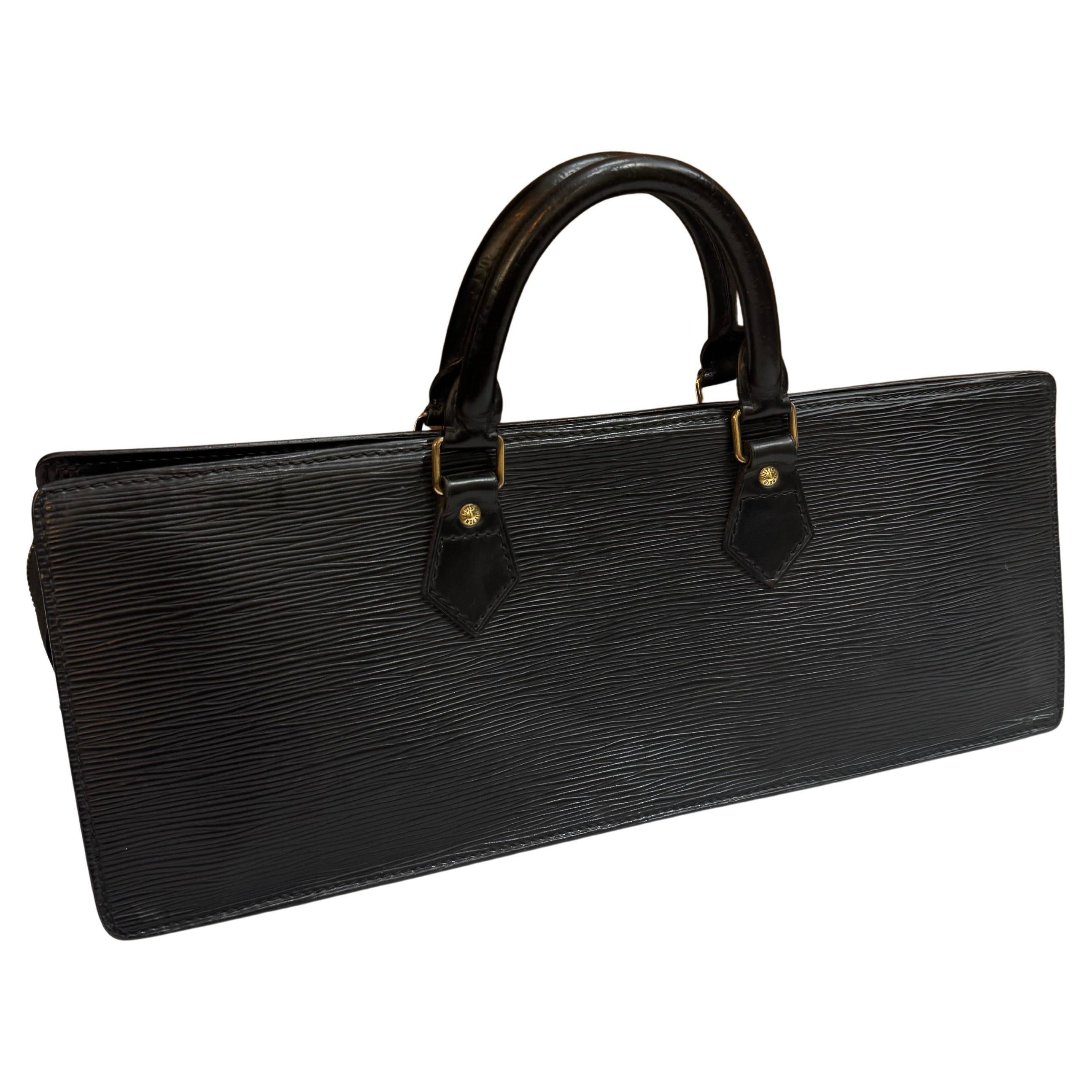 This vintage LOUIS VUITTON Sac Traingle handbag is crafted of Louis Vuitton’s signature Epi calfskin leather in black featuring brass hardware and rolled smooth calfskin leather handles. Top zipper closure opens to a black leather interior with a