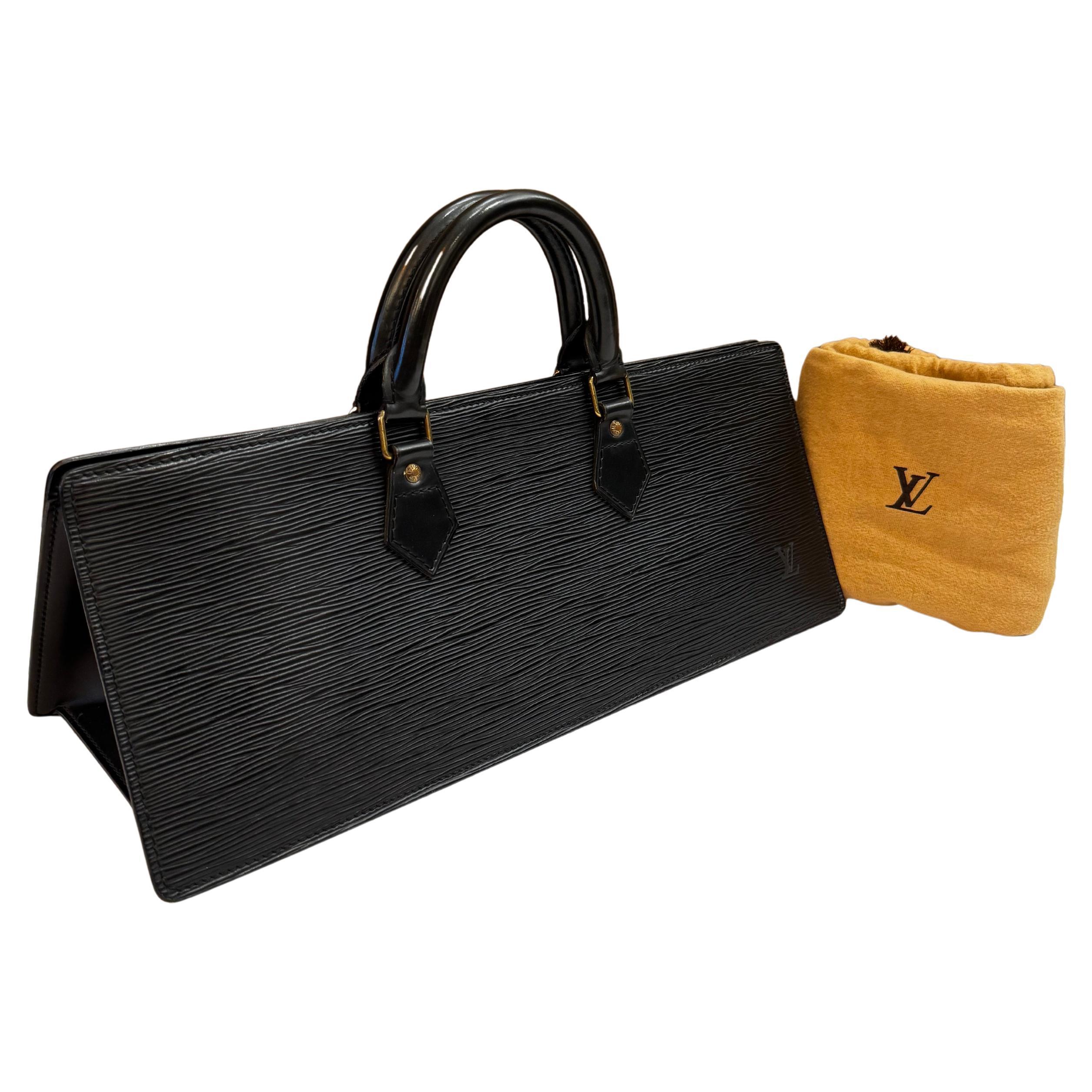 This vintage LOUIS VUITTON Sac Traingle handbag is crafted of Louis Vuitton’s signature Epi calfskin leather in black featuring brass hardware and rolled smooth calfskin leather handles. Top zipper closure opens to a leather interior in black with a