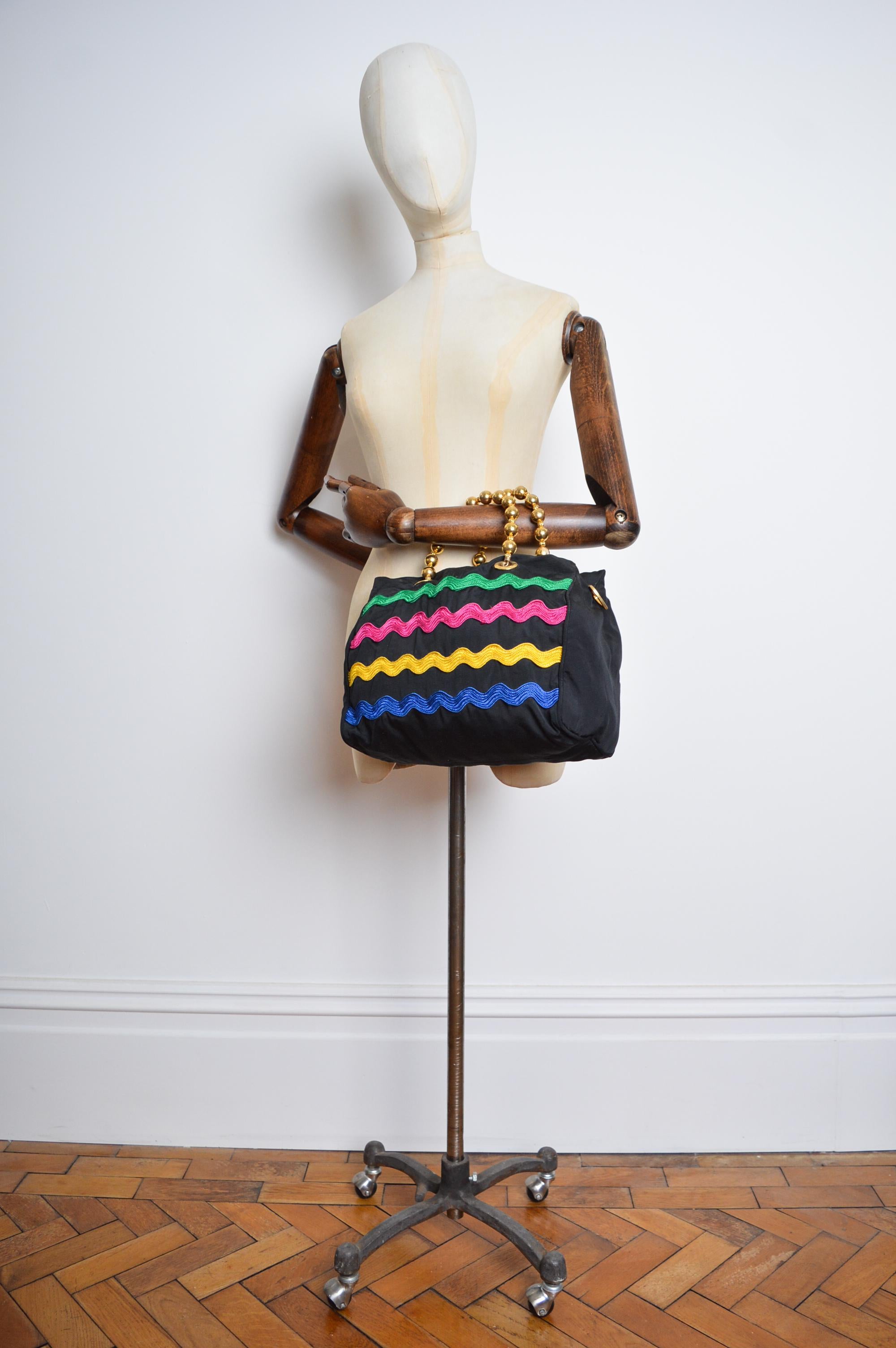 Un sac MOSCHINO Vintage circa 1990, fabriqué à partir d'un tissu en nylon noir avec des garnitures colorées en forme de lacets de chaussures et des poignées en perles dorées, produit par REDWALL.   

FABRIQUÉ EN ITALIE.   

Caractéristiques ; Deux