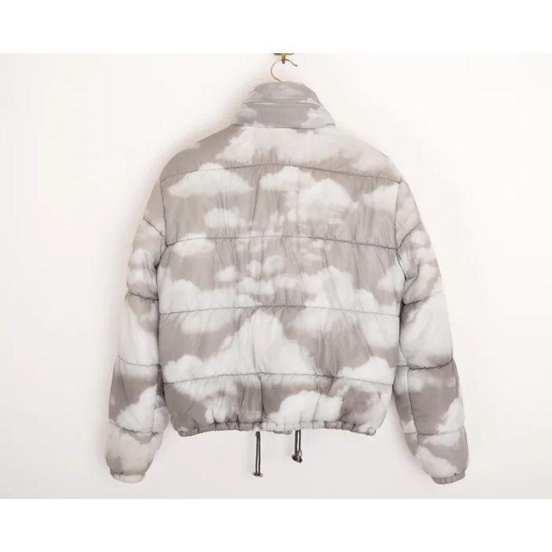 Vintage Moschino 1990's Cloud print puffer Jacket in a grey and white colourway. Slightly cropped in the body, featuring a packaway hood and central line zip fasten.

Features:
Zip fasten closure
x2 exterior front pockets
Drawstring waist
Concealed