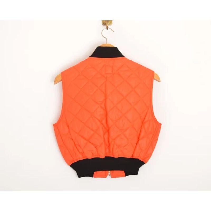 Incredible Vintage 1990's Moschino jeans quilted, cropped bomber vest, in satsuma orange with contrast black piping and iconic peace shaped metal hardware. 

MADE IN ITALY

Features:
Tall collar
Zip closure Hip pockets
Gently elasticated Collar &