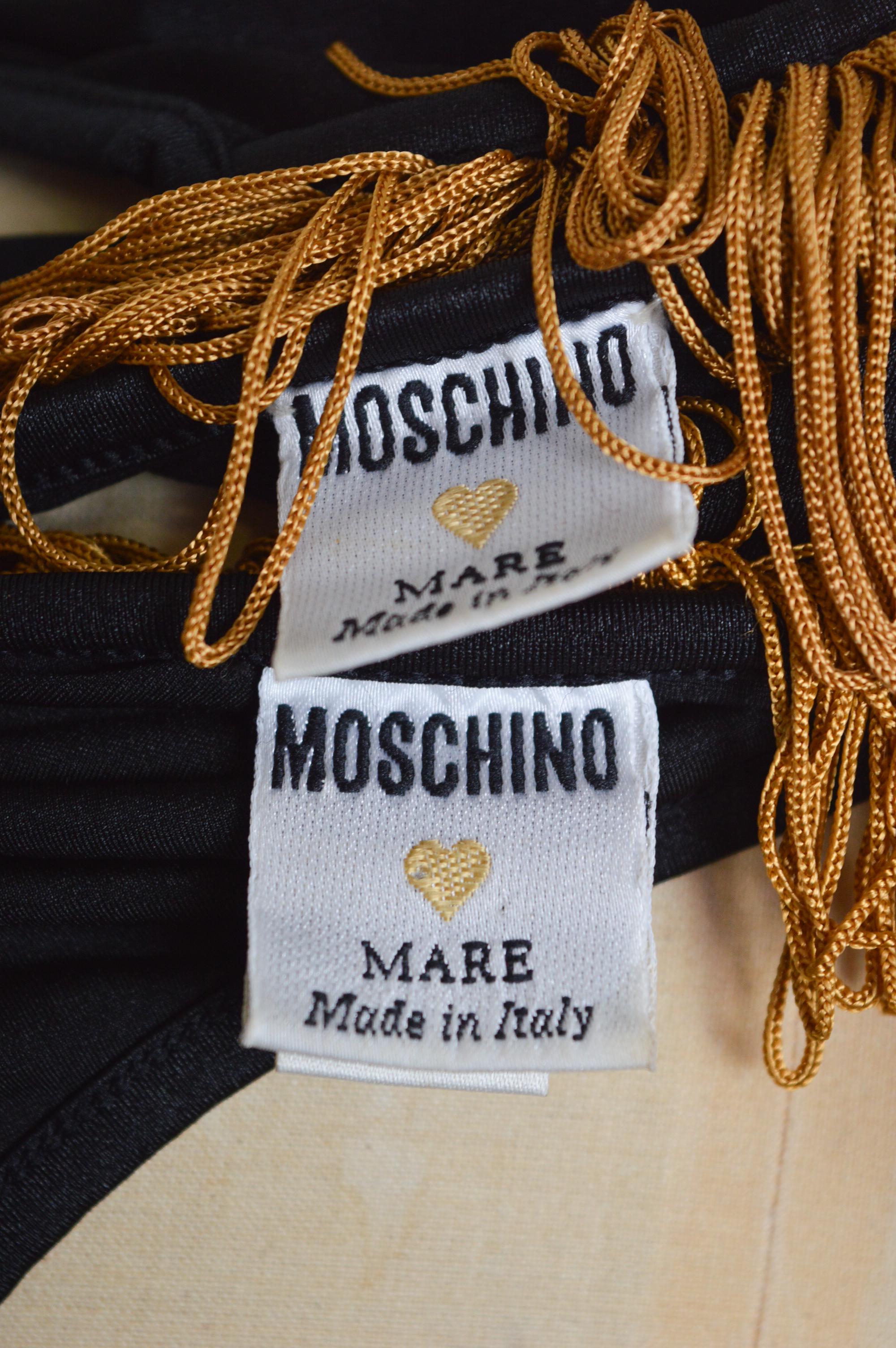 Fabelhaftes Vintage Moschino Showgirl Badeanzug Set in Schwarz & Gold aus den frühen 1990er Jahren, entworfen von Franco Moschino.  

GEFERTIGT IN ITALIEN.  

Dieses epische Bikini-Set besteht aus einem fransenbesetzten Bralet mit sternförmig