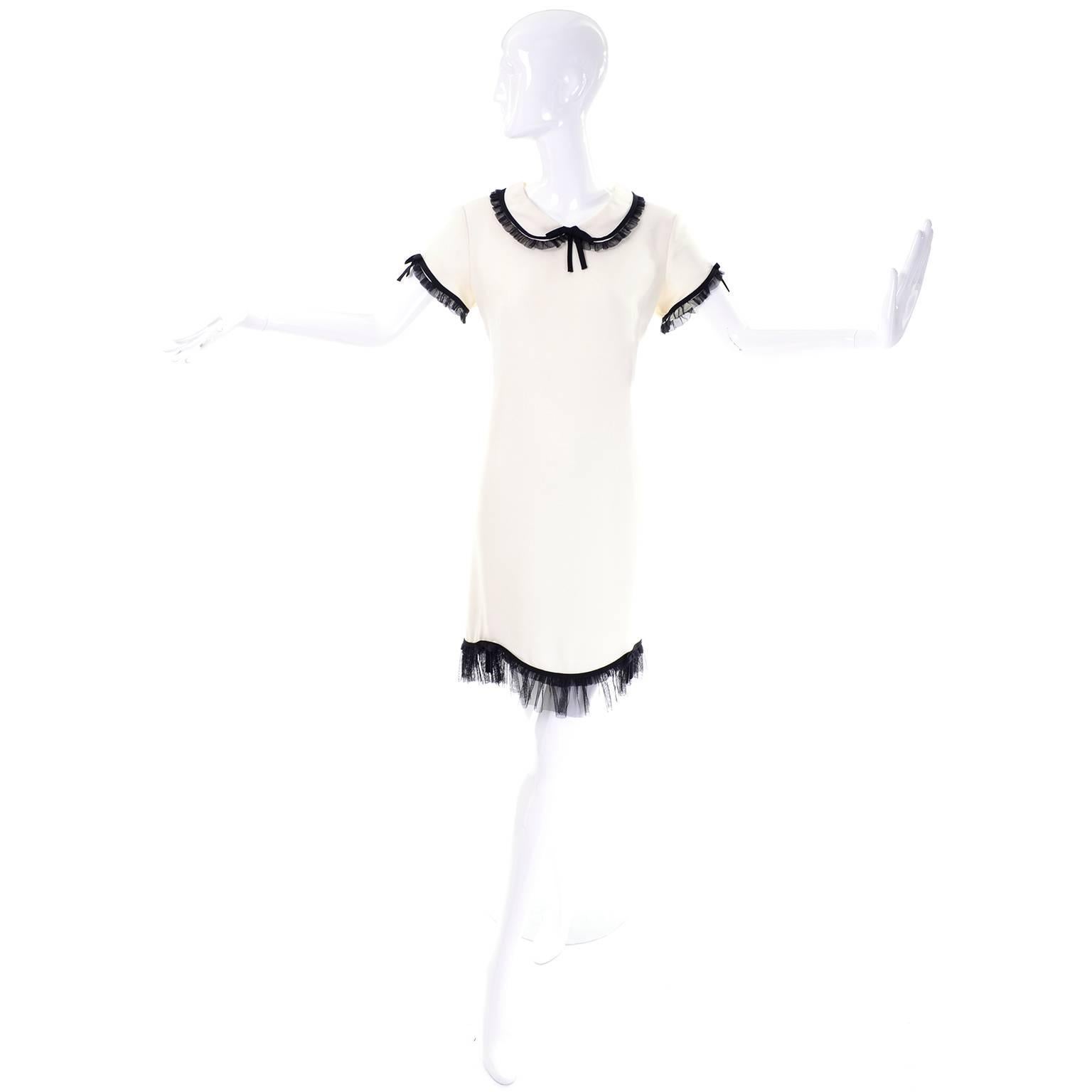 This adorable vintage short sleeved dress from Moschino is made in an ivory rayon / acetate blend crepe and has black ruffled netting or tulle at the collar, hemline, and sleeves.  This Cheap and Chic by Moschino dress was made in Italy,  The dress
