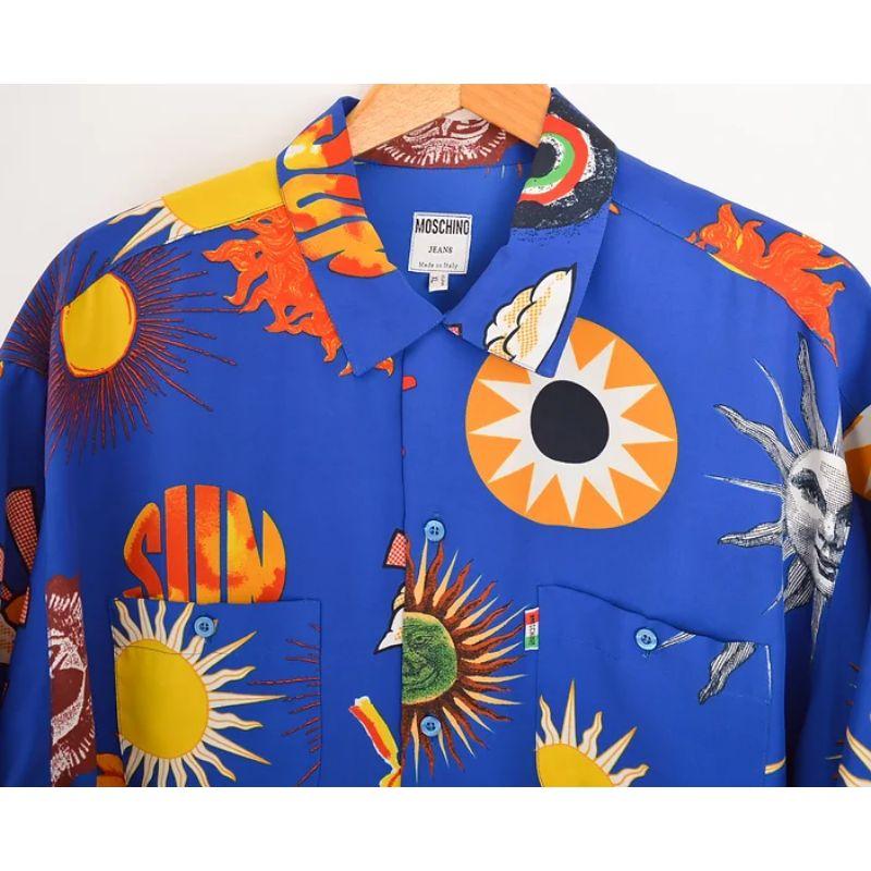 Epic Vintage 1990's Moschino 'Smiley Face & Suns' patterned button down Shirt in an electric blue colour-way.

Features:
Short sleeves
Chest pockets
Central line button fasten
Oversized fit
100% Polyester

Measurements given in inches;
Sizing: Pit