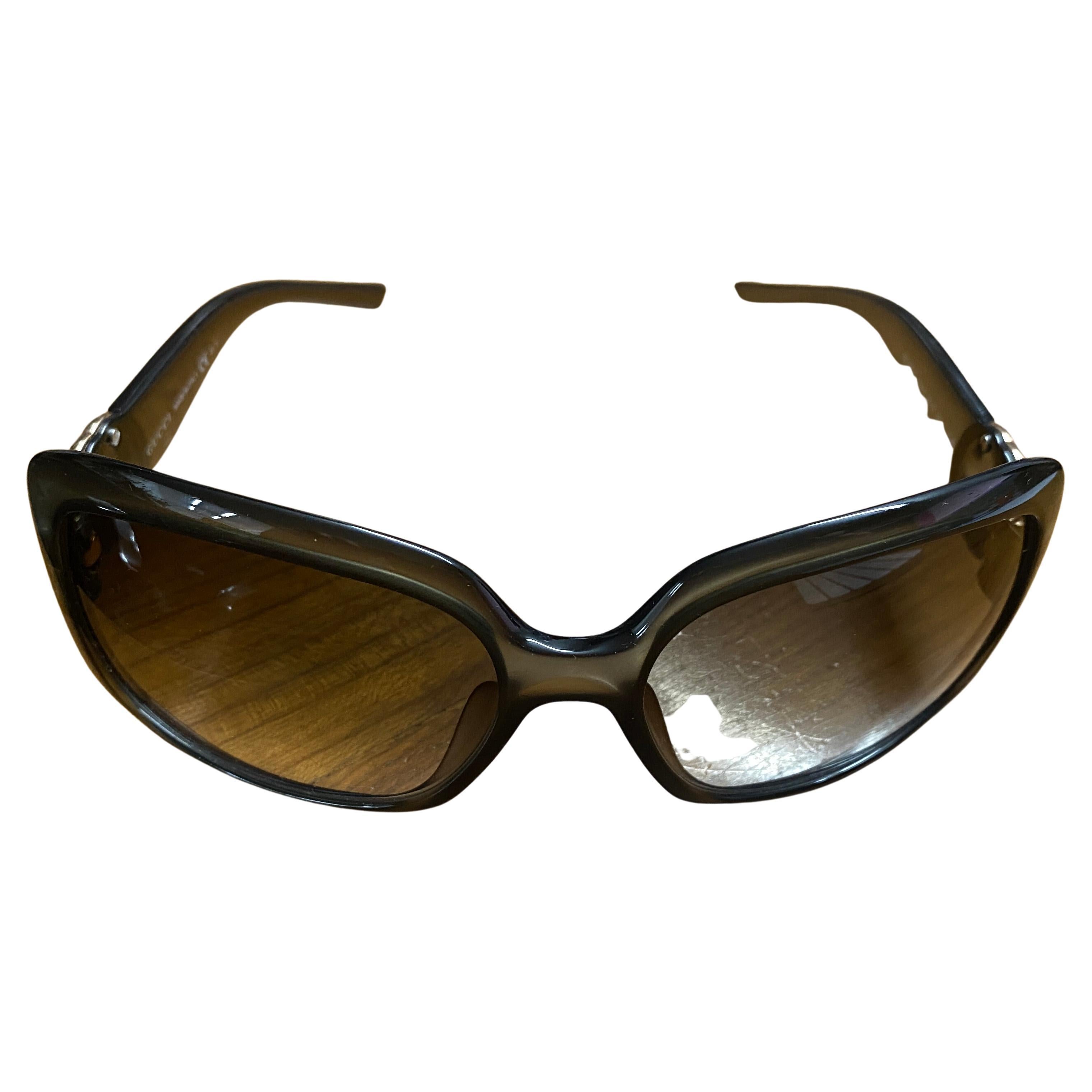 A pair of brown Gucci sunglasses with original case, sunglasses are in very good conditions, only the case has some signs of use and age, they are a luxurious addition to any fashion enthusiast's collection. Gucci is a renowned Italian fashion house