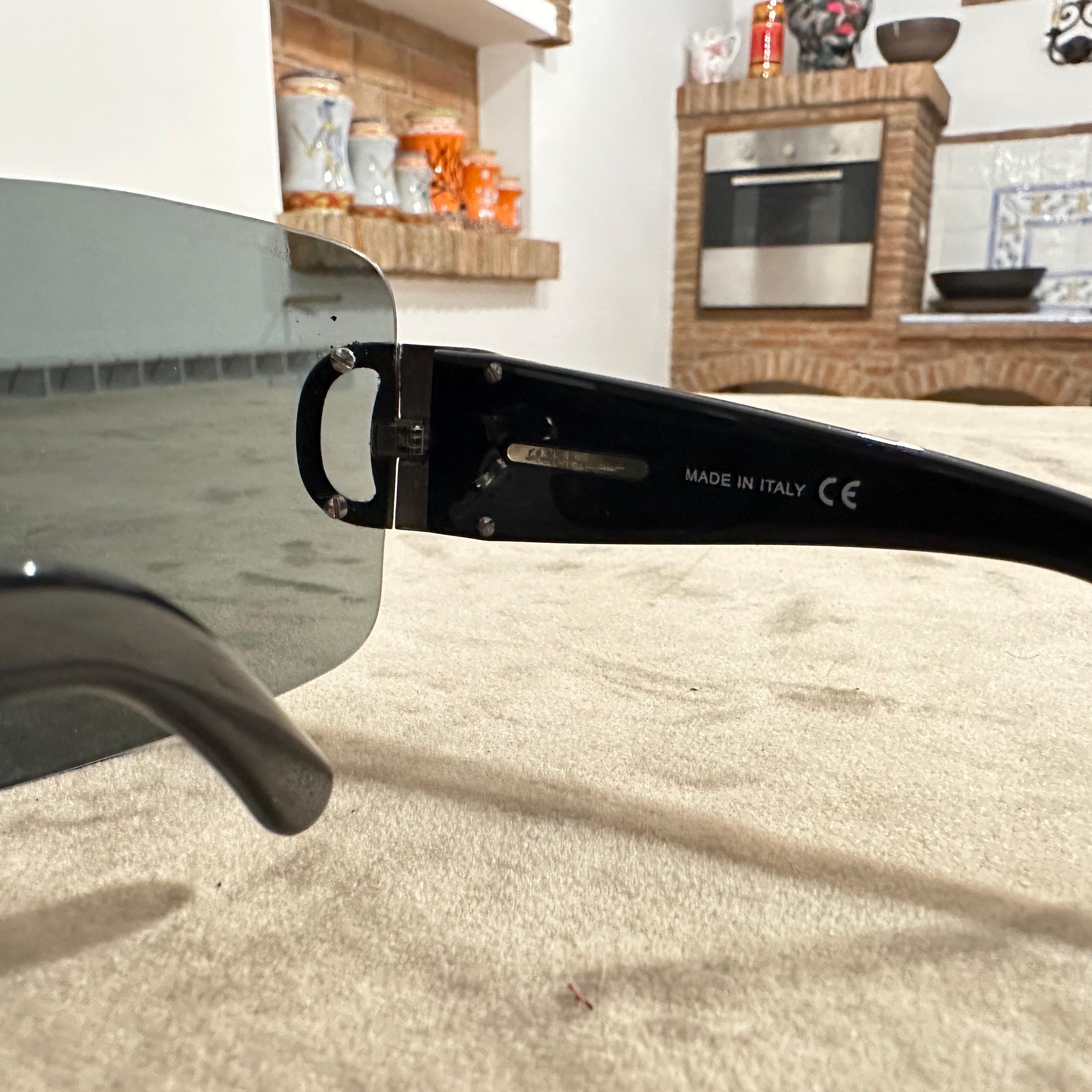 Ces lunettes de soleil Masque surdimensionné Ferragamo vintage des années 1990 sont un exemple frappant de lunettes audacieuses et futuristes de l'époque. Dotées d'un design enveloppant à verre unique, ces lunettes de soleil incarnent l'esthétique