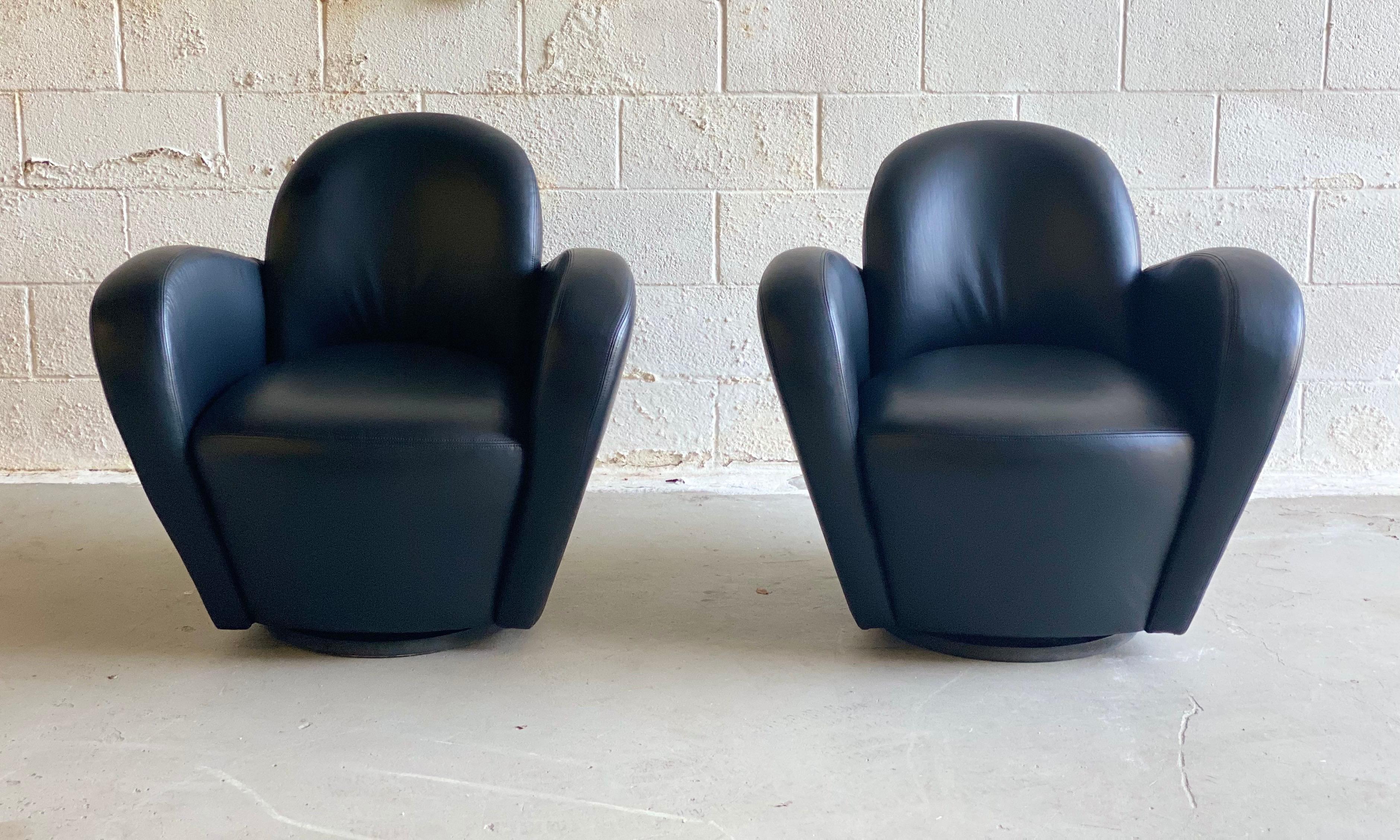 We are very pleased to offer a sculptural, incredible pair of wrap-around barrel swivel chairs by Michael Wolk for Preview, circa the 1990s. These beautiful swivel ergonomic tulip shaped chairs showcase a black leather. In great condition with