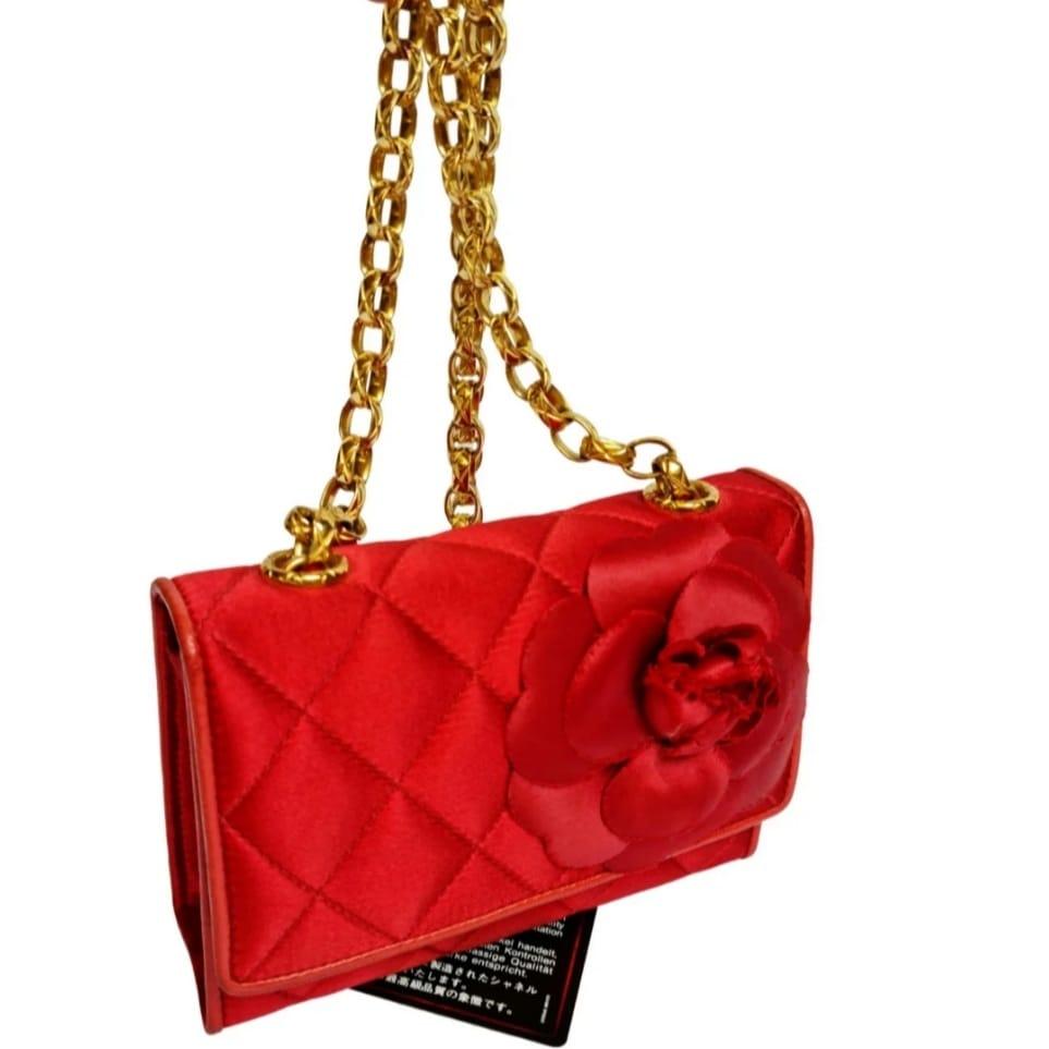 Vintage Mini-Satin-Kamelien-Tasche aus den 90er Jahren. Schönes leuchtendes Rot mit klassischer Kamelienblütenverzierung. Leichte Reibung an den Ecken. Das Kameliendetail ist durch die Lagerung etwas abgeflacht. Artikel Serie #2. Kommt mit seiner