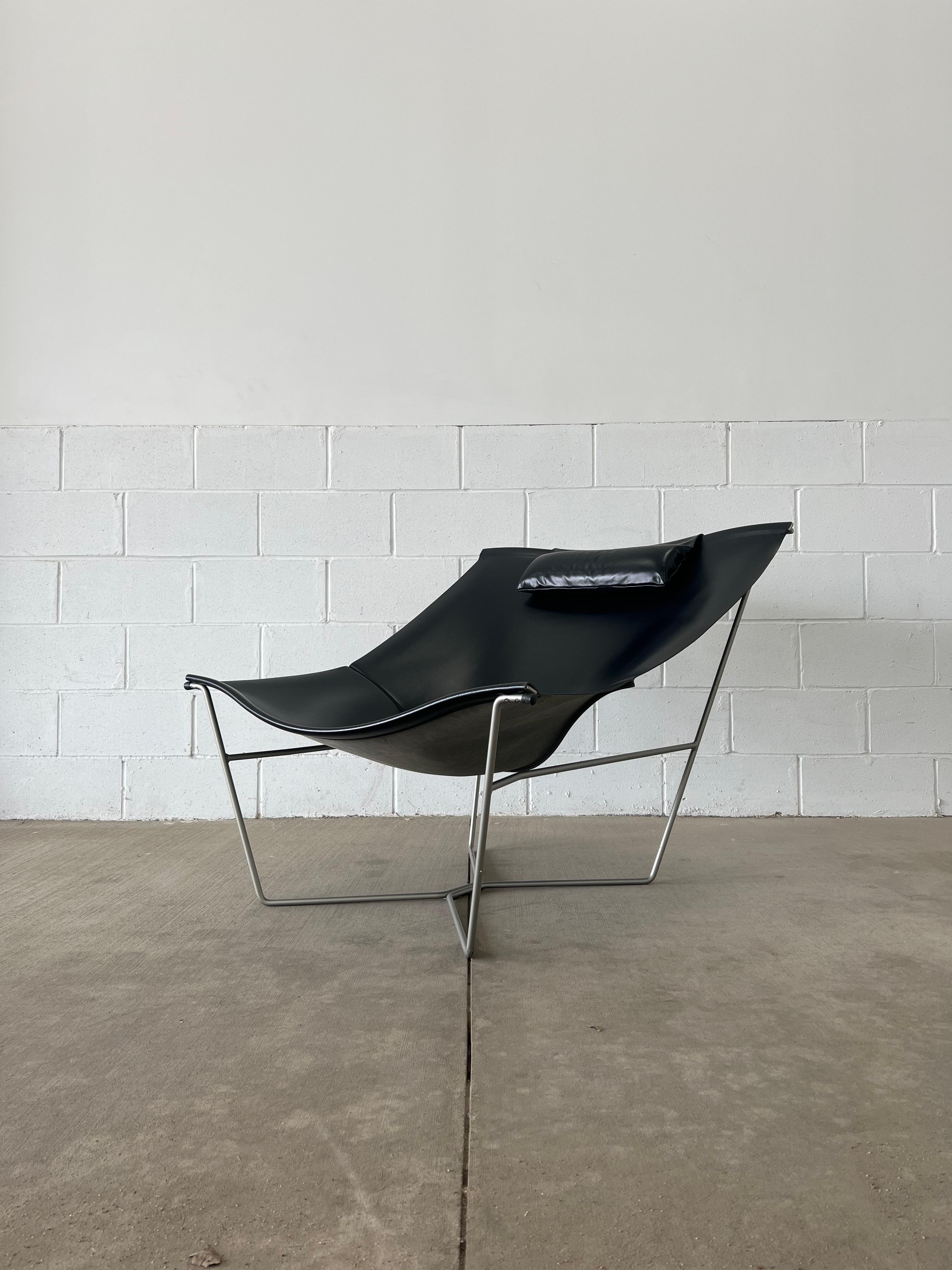Semana black leather sling chair by David Weeks for Habitat (unmarked), UK, 1990s. The leather is in excellent condition as is the pillow which is placed on the top, held in place by a counterweight. The grey steel frame has some minor scratches and
