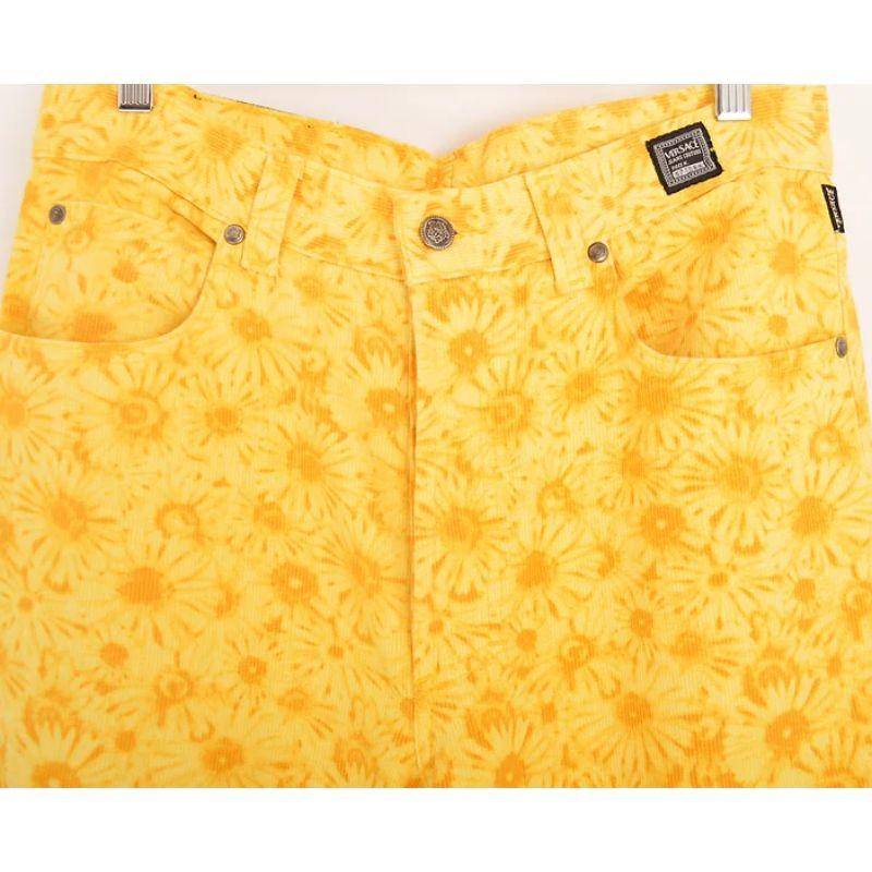 Hervorragende Versace Jeans Couture Jeans mit hoher Taille aus den frühen 1990er Jahren in einem leuchtend gelben, floralen Gänseblümchen-Musterdruck. 

Merkmale:
Knopfverschluss
Klassisches x4-Taschen-Design
Versace Seite und Rückseite