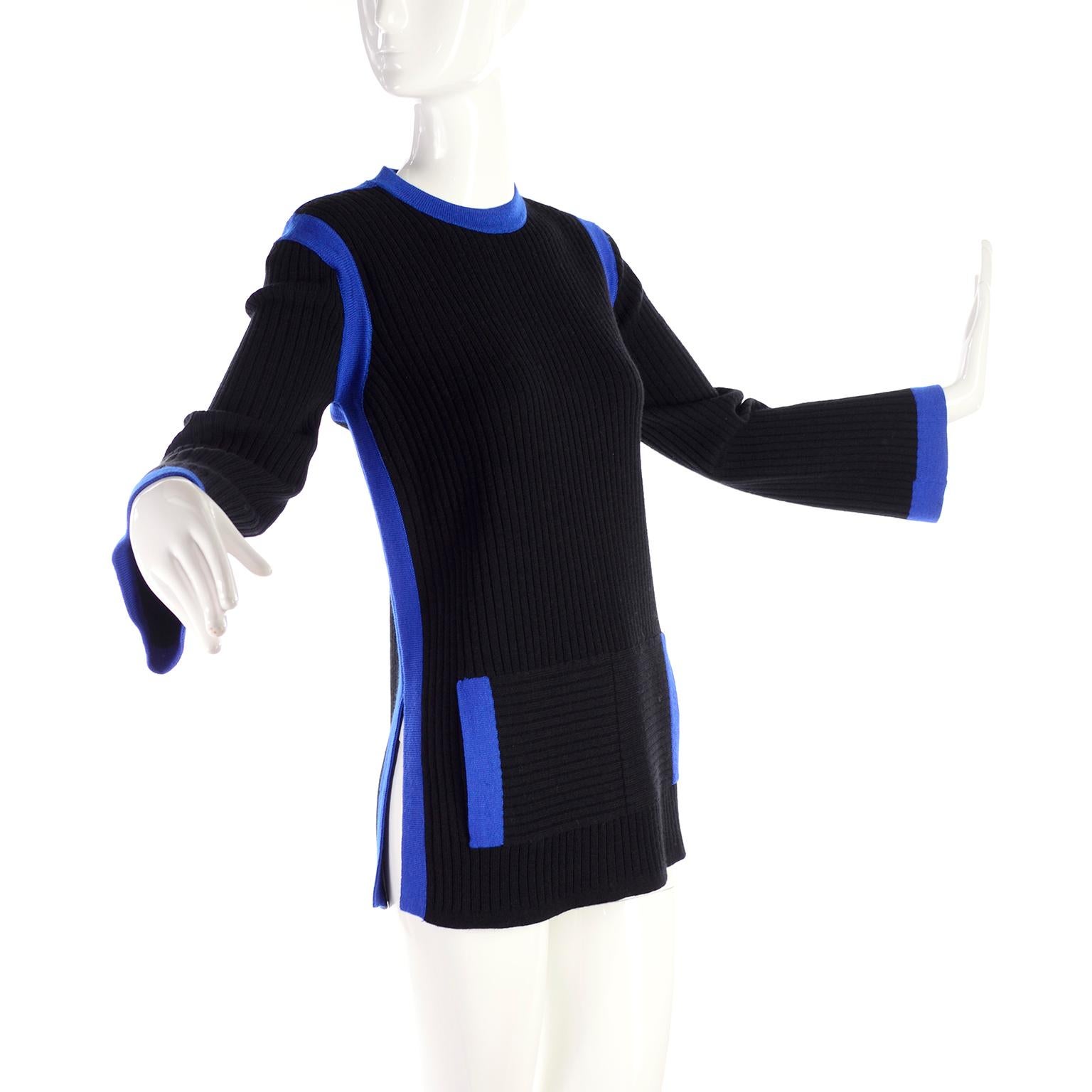 This is a wonderful vintage sweater from Yves Saint Laurent in black wool knit with pretty blue trim. There are buttons on the shoulders, faux front pockets and side slits.  Labeled a size large, the top can fit a medium or a smaller large.  Made in