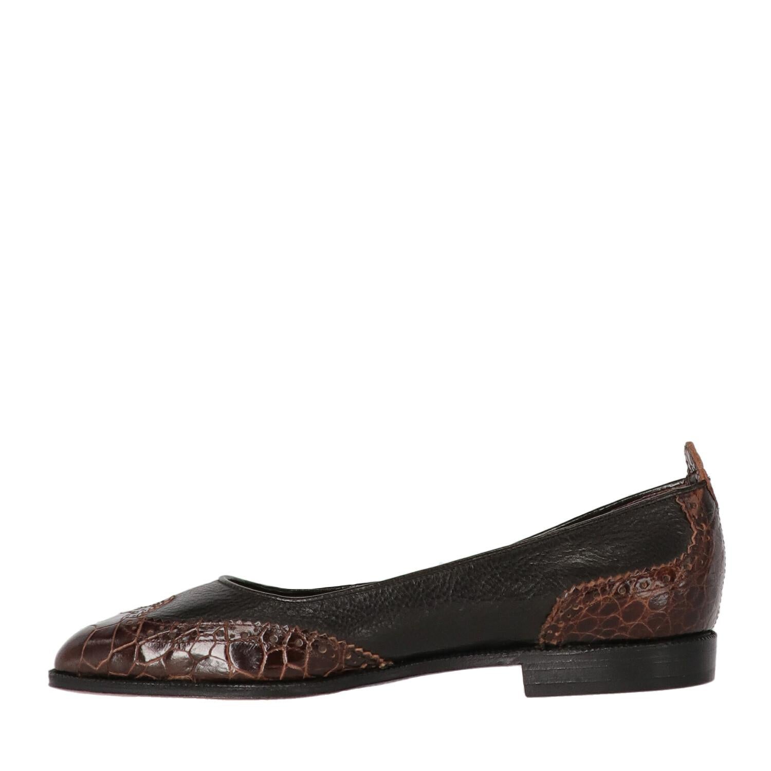 Ballerine William Black in pelle con inserti in coccodrillo marrone. Modello con classica decorazione traforata e punta a mandorla.

Una delle due scarpe ha la pelle leggermente opaca, come mostra la foto.

Si prega di notare che questo articolo non