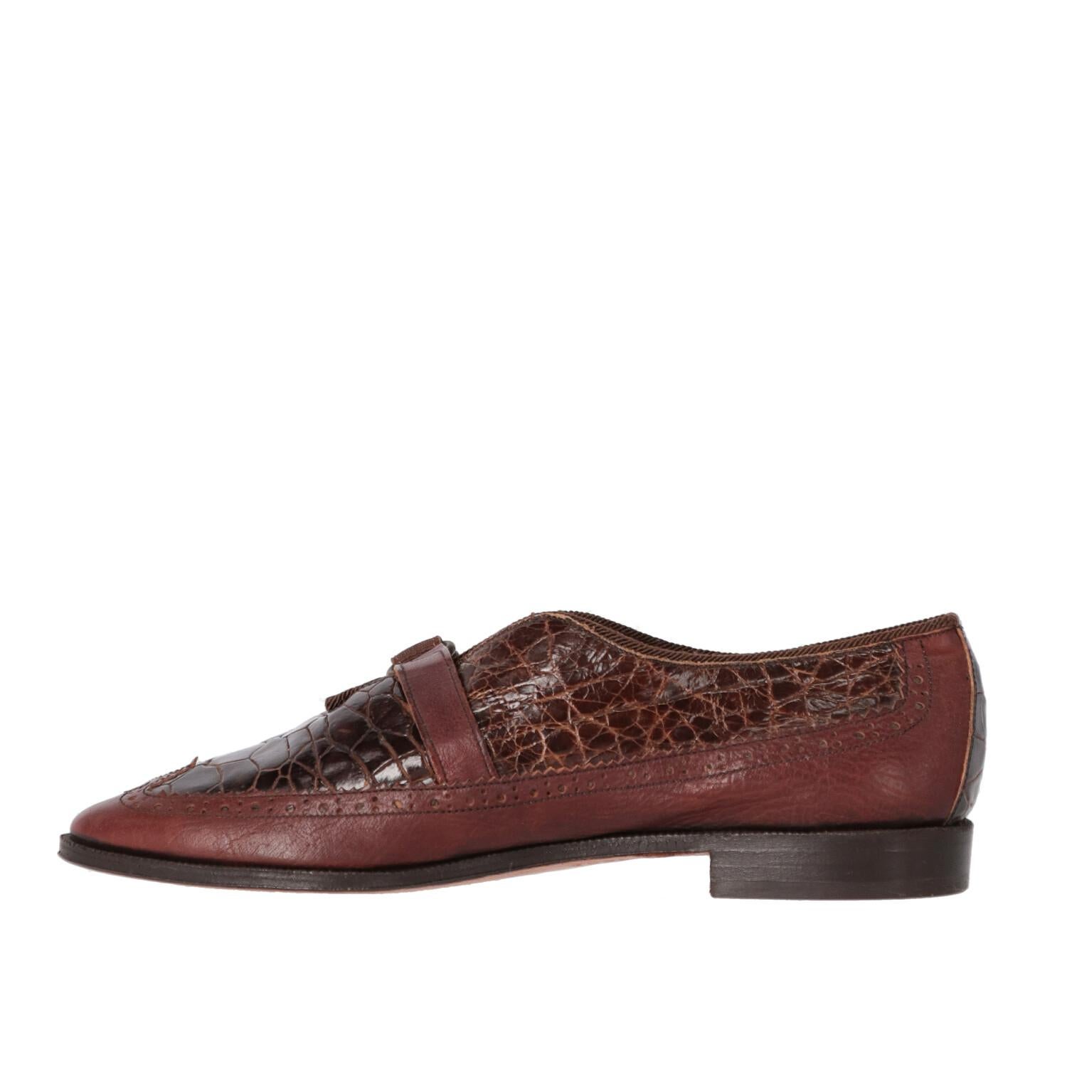 William brown crocodile leather loafers with almond toe. Perforated brogue details and buckle strap on the instep.

Please note that this item cannot be shipped outside EU.

The product has slightly oxidized metal parts.
Years: 90s

Made in