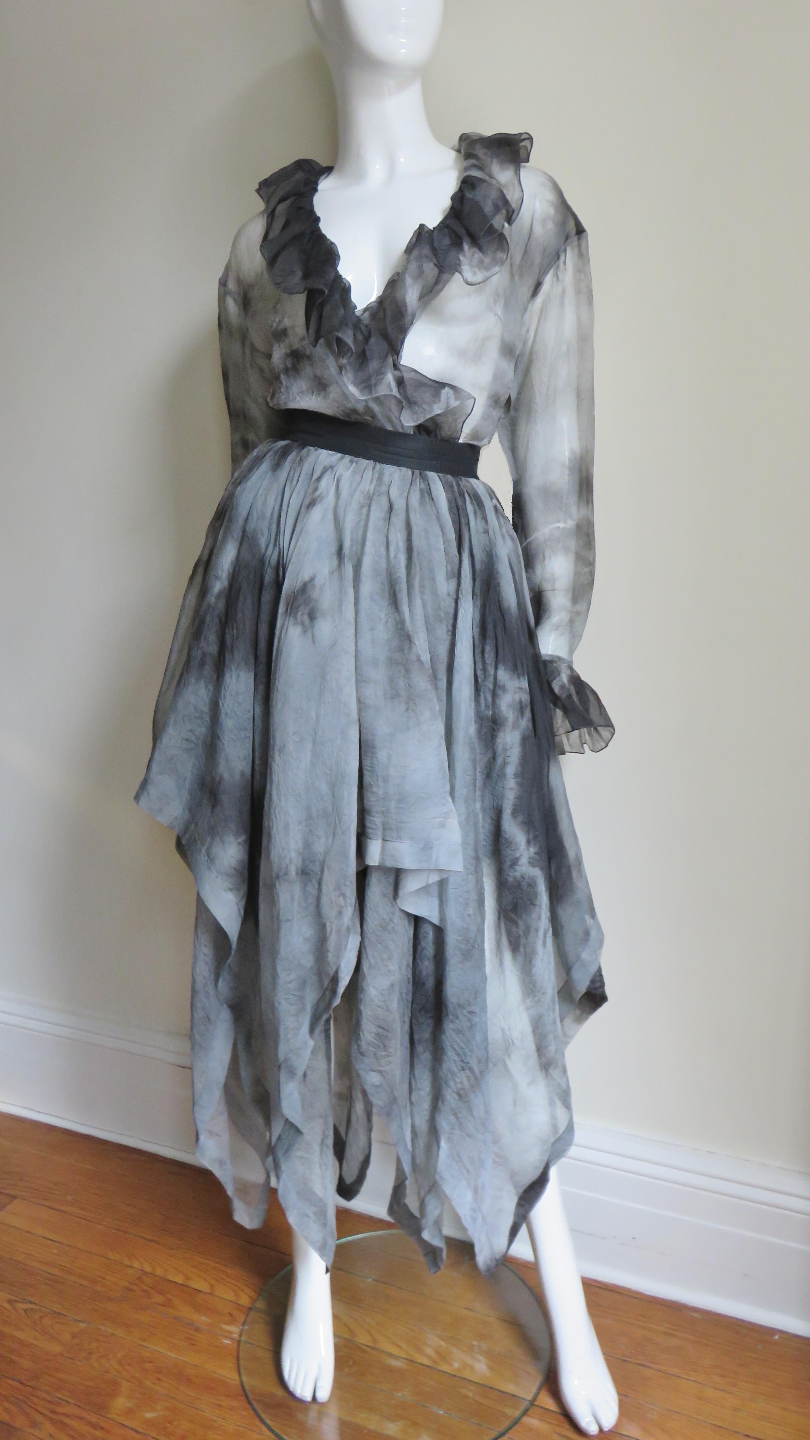 A fabulous semi sheer silk organza skirt and top set from Workers For Freedom, London in mint grey and black tie dye pattern.  The long top has a ruffle around the neck and the burnished dark grey metal button cuffs. Two skewed layers of skirt with