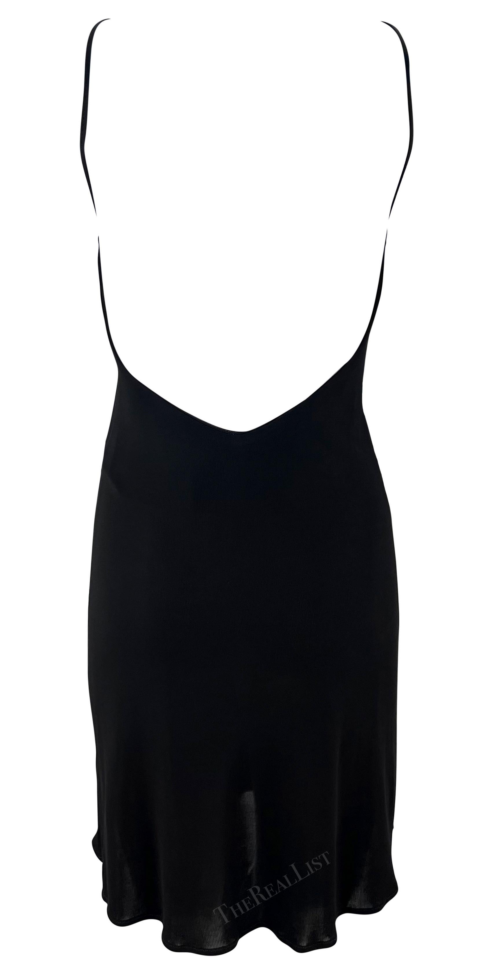 Presenting a chic black knit Yigal Azrouël mini dress. From the late 1990s, this mini dress features a bandeau neckline, spaghetti strap, and an exposed back. The dress is made complete with a lightly flared hem and a small slit on either side.