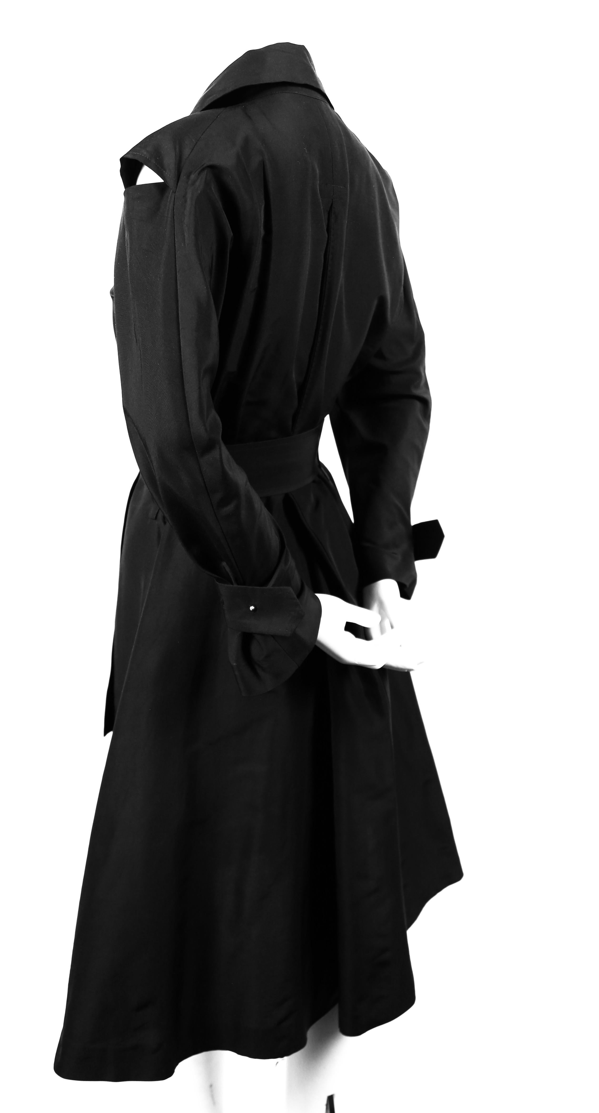 Very unique, black, belted coat dress with cut-out shoulders designed by Yohji Yamamoto dating to the late 1990's. Very dramatic silhouette. Labeled a size '2', which best fits a US 4 to 6. Measurements are difficult to take due to wrap closure.