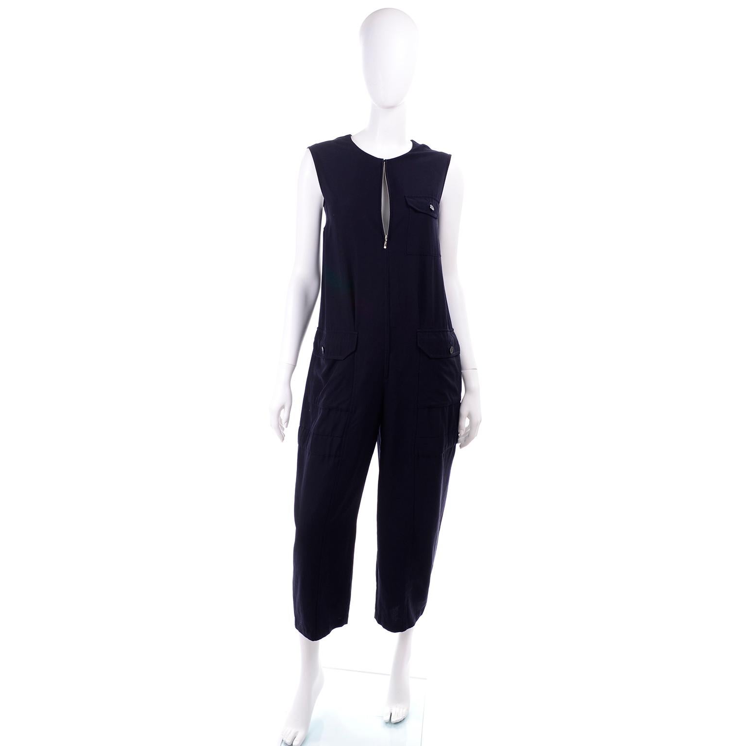 This is a versatile 1990s navy wool sleeveless utility jumpsuit designed by Yohji Yamamoto.  The jumpsuit closes in front with a CF zipper, and has 3 pockets; 1 patch pocket at the breast, and 2 side seam slit pockets underneath 2 hip patch pockets.