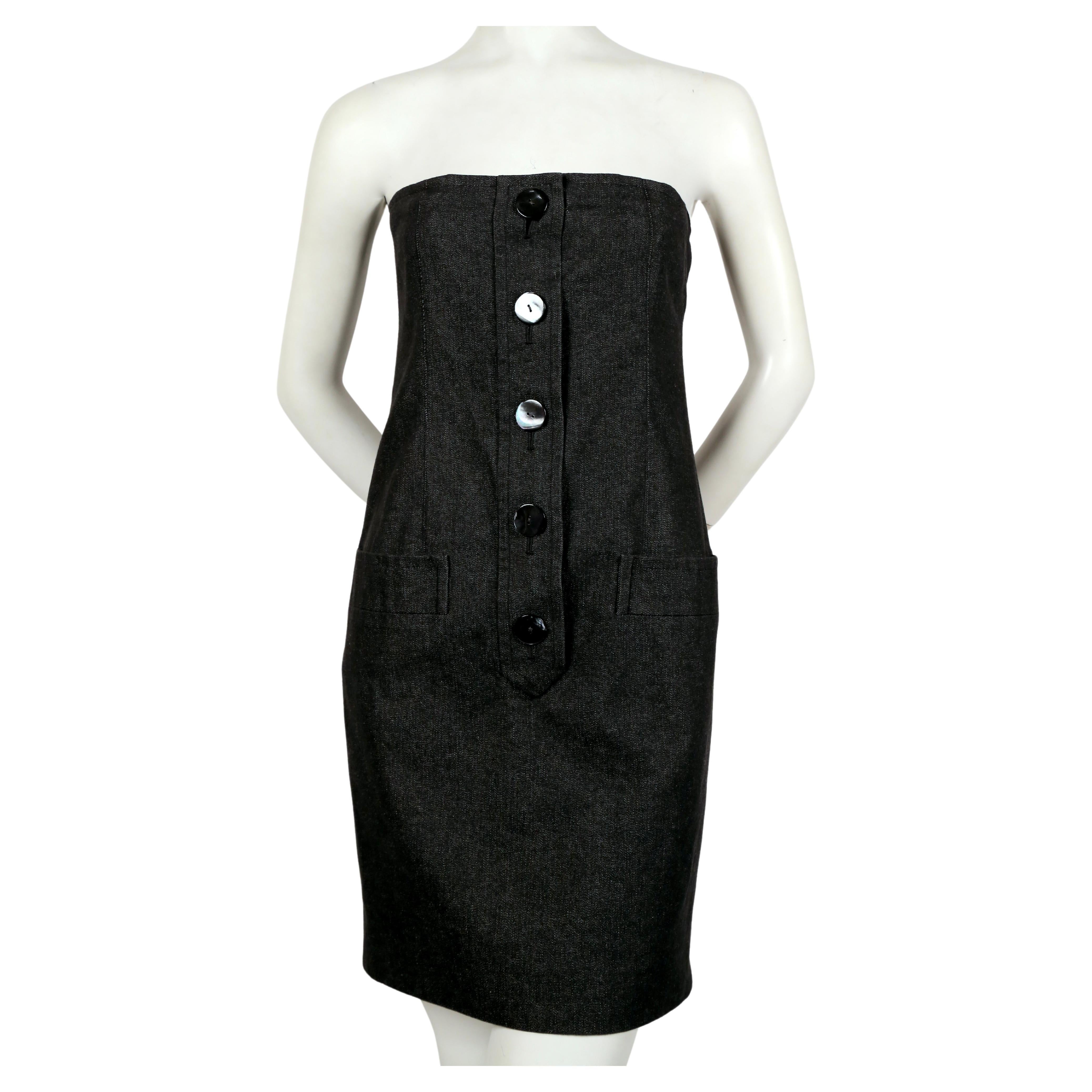 Strapless, black denim dress with oversized shell buttons and horizontal pockets at hips from Yves Saint Laurent dating to the late 1980's, early 1990's. No size is indicated however this best fits a US 2 or 4. Approximate measurements: bust 30
