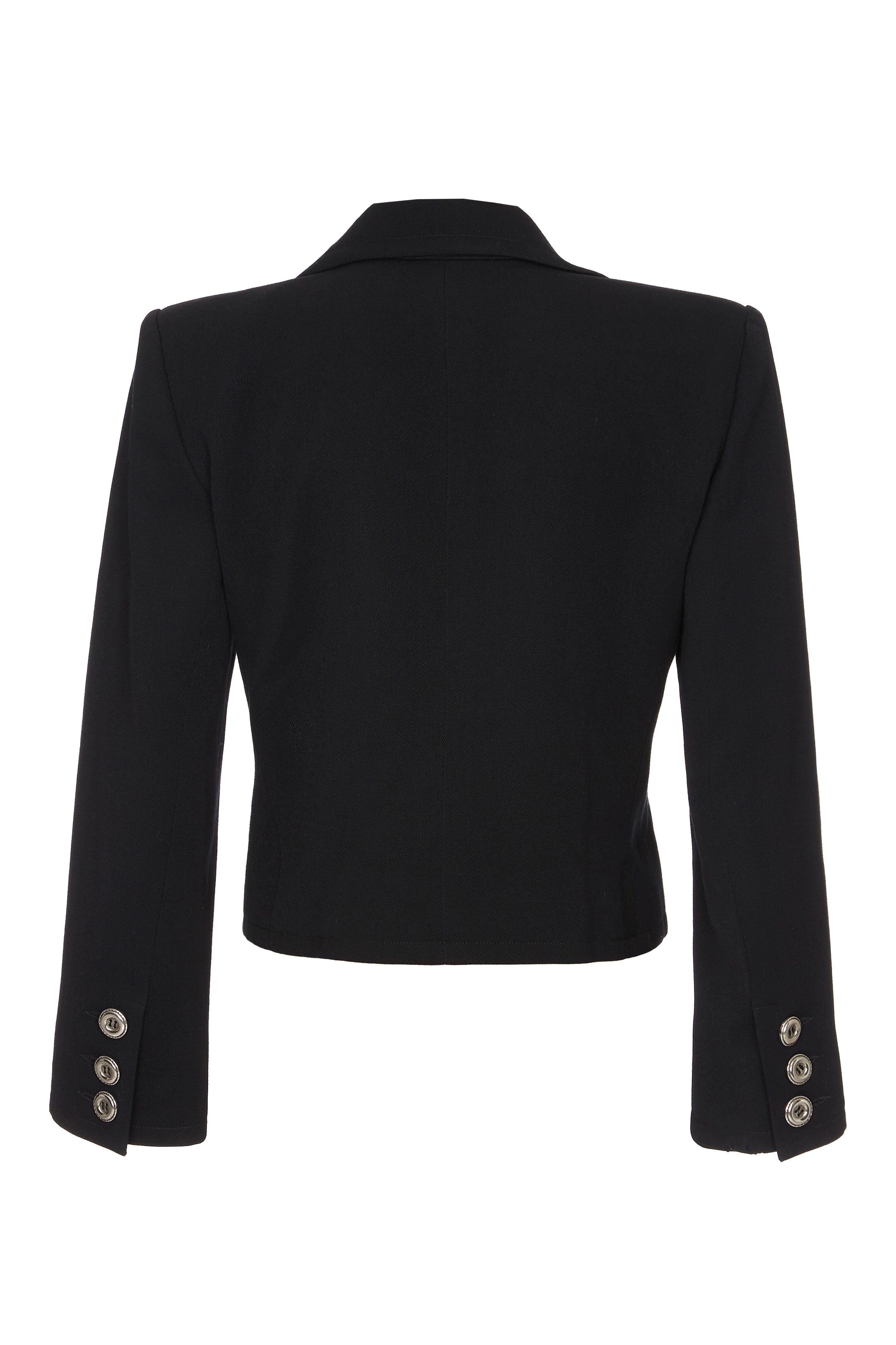 This striking Yves Saint Laurent 1990s black double breasted short cropped jacket is of superb quality and in excellent condition. With slick tailoring and a stylish crop cut, the wide set peak lapel forms a plunging V at the neckline and alluring