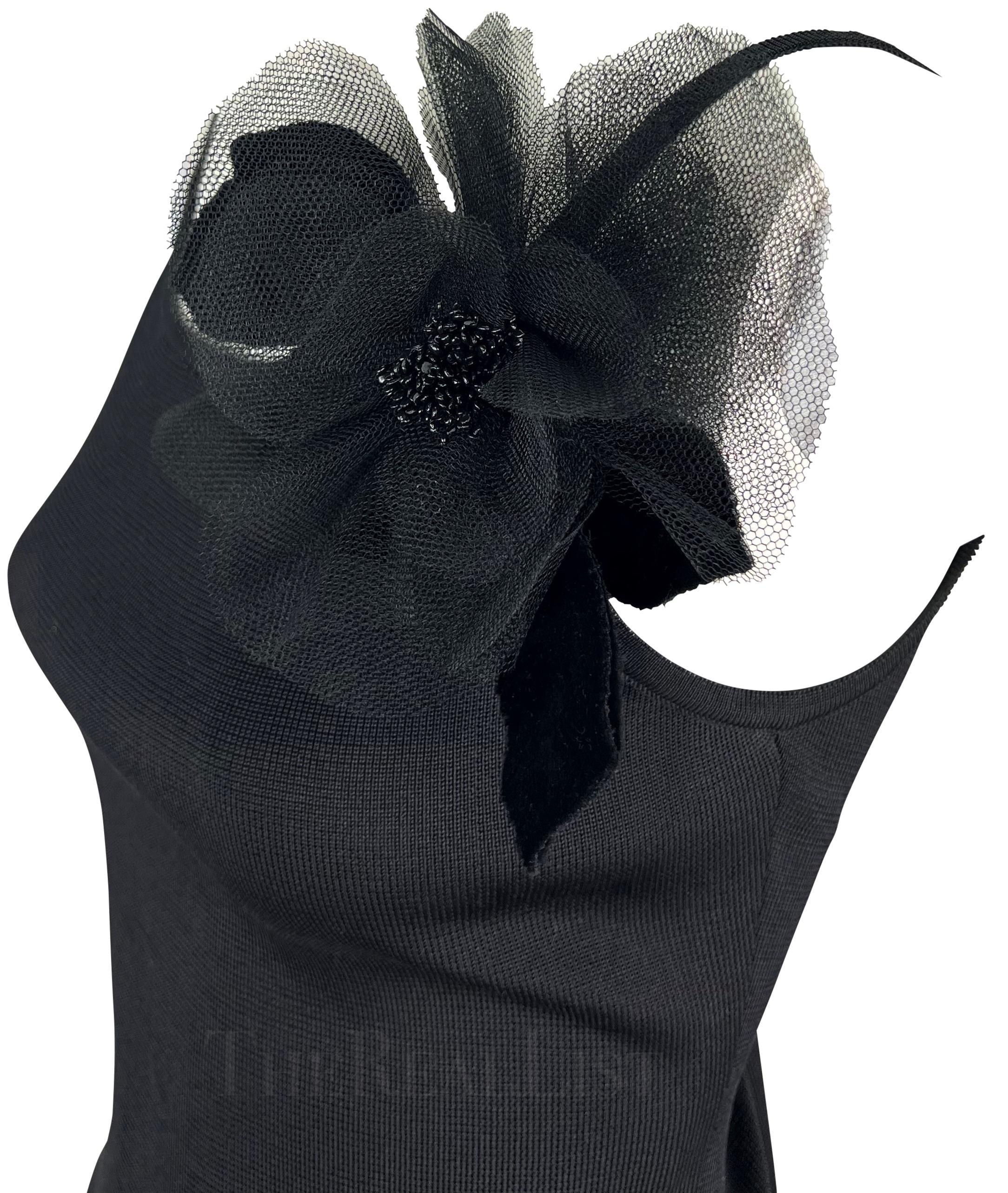 Ich präsentiere Ihnen ein fabelhaftes schwarzes Yves Saint Laurent-Strickhemd. Dieses Oberteil aus den 1990er Jahren hat einen Rundhalsausschnitt, Spaghetti-Träger und eine große schwarze Blumenapplikation auf einer Schulter.

Ungefähre Maße:
Größe
