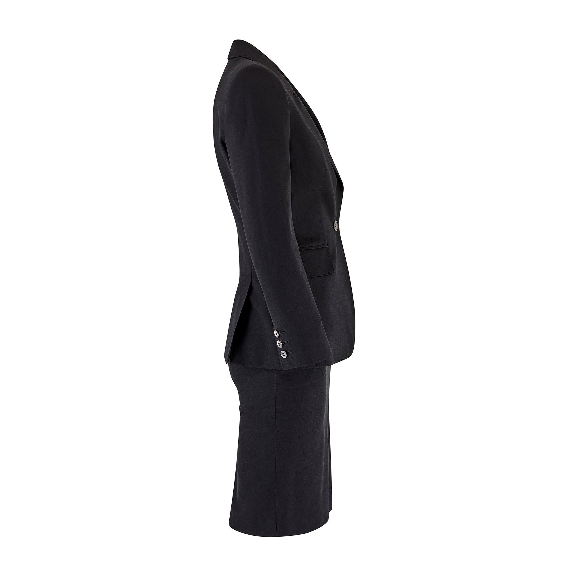This timeless black wool skirt suit was designed by French fashion house Yves Saint Laurent during the late 1990s or 2000.  It can likely be attributed to the great and late Alber Elbaz who briefly worked for the House from 1998 to 2000 having