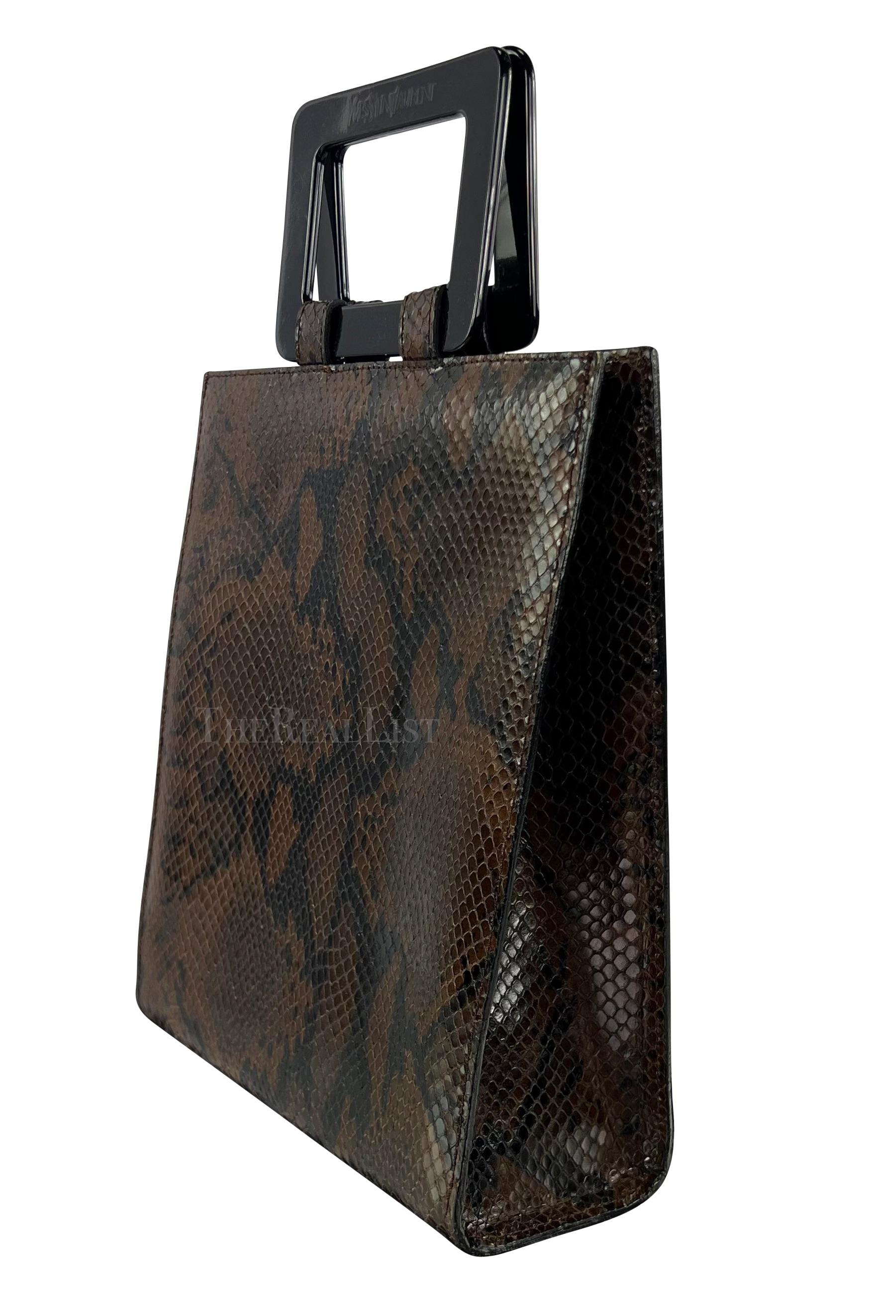 Voici un fabuleux sac à main en python marron Yves Saint Laurent Rive Gauche. Datant des années 1990, le design structuré de ce sac met en valeur la beauté exotique du python marron foncé, ce qui en fait une véritable pièce maîtresse. Les poignées