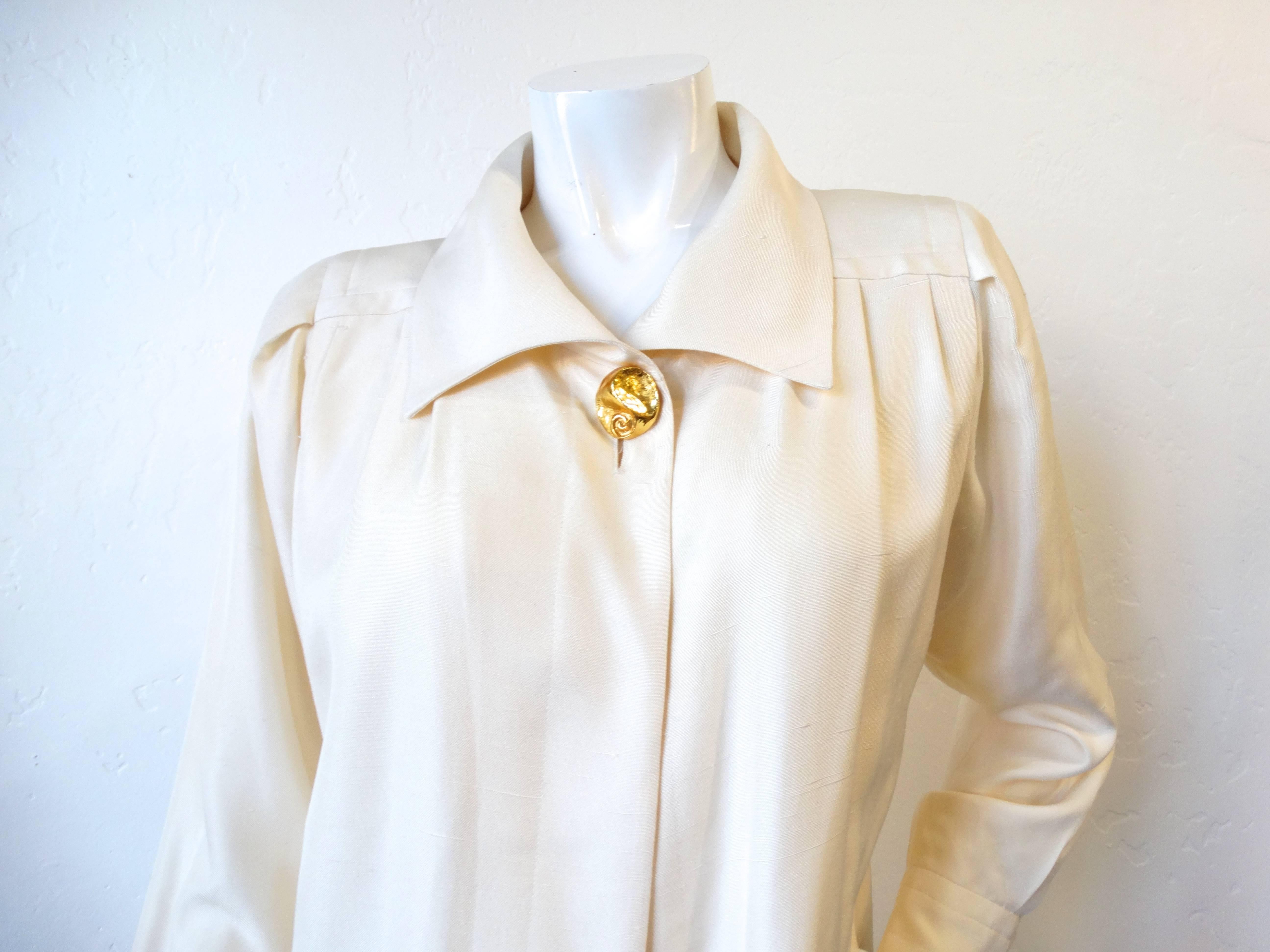 Dress like a Parisian in our adorable 1990s Yves Saint Laurent cream jacket! Made of a slightly distressed cream colored silk fabric, contrasted with large gold statement buttons at the neck and on each of the cuffs. Open, relaxed construction,